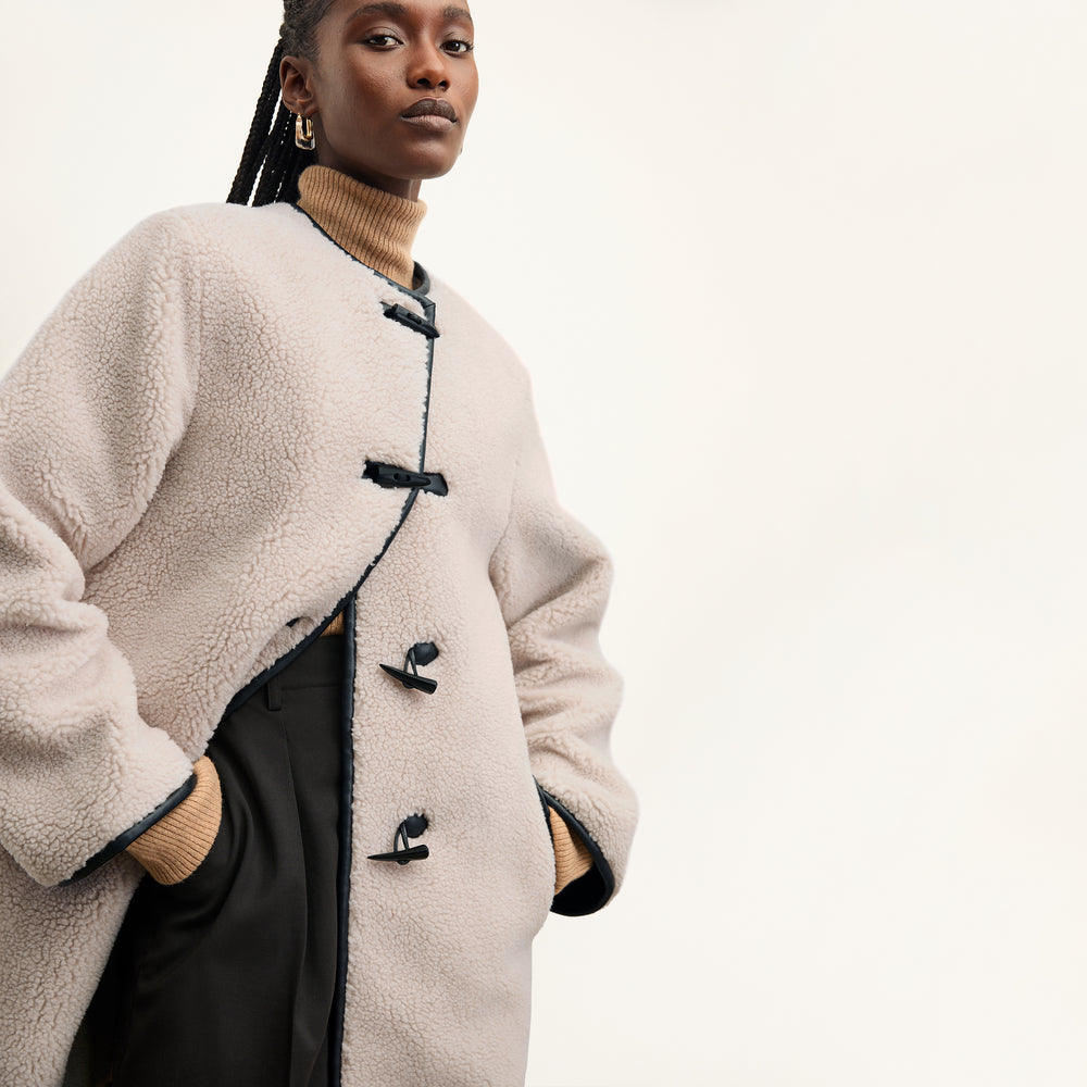 front image of a woman wearing the katari jacket in travertine
