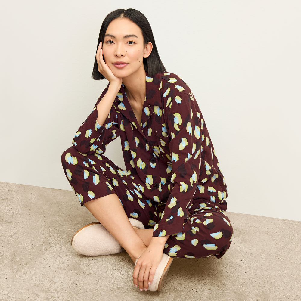 front image of a woman sitting wearing the signature pajama set in bengal print