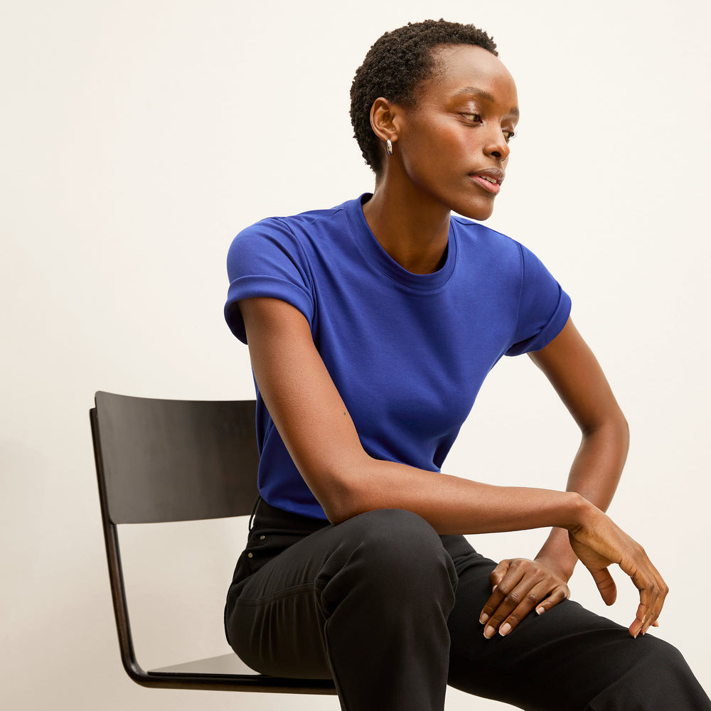 front image of a woman wearing the leslie t-shirt in bright indigo