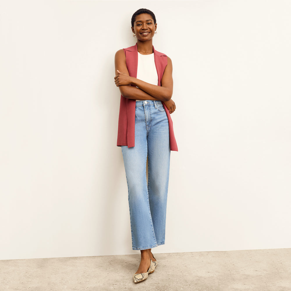 front image of a woman sitting wearing the frame le jane ankle jeans in deepwater