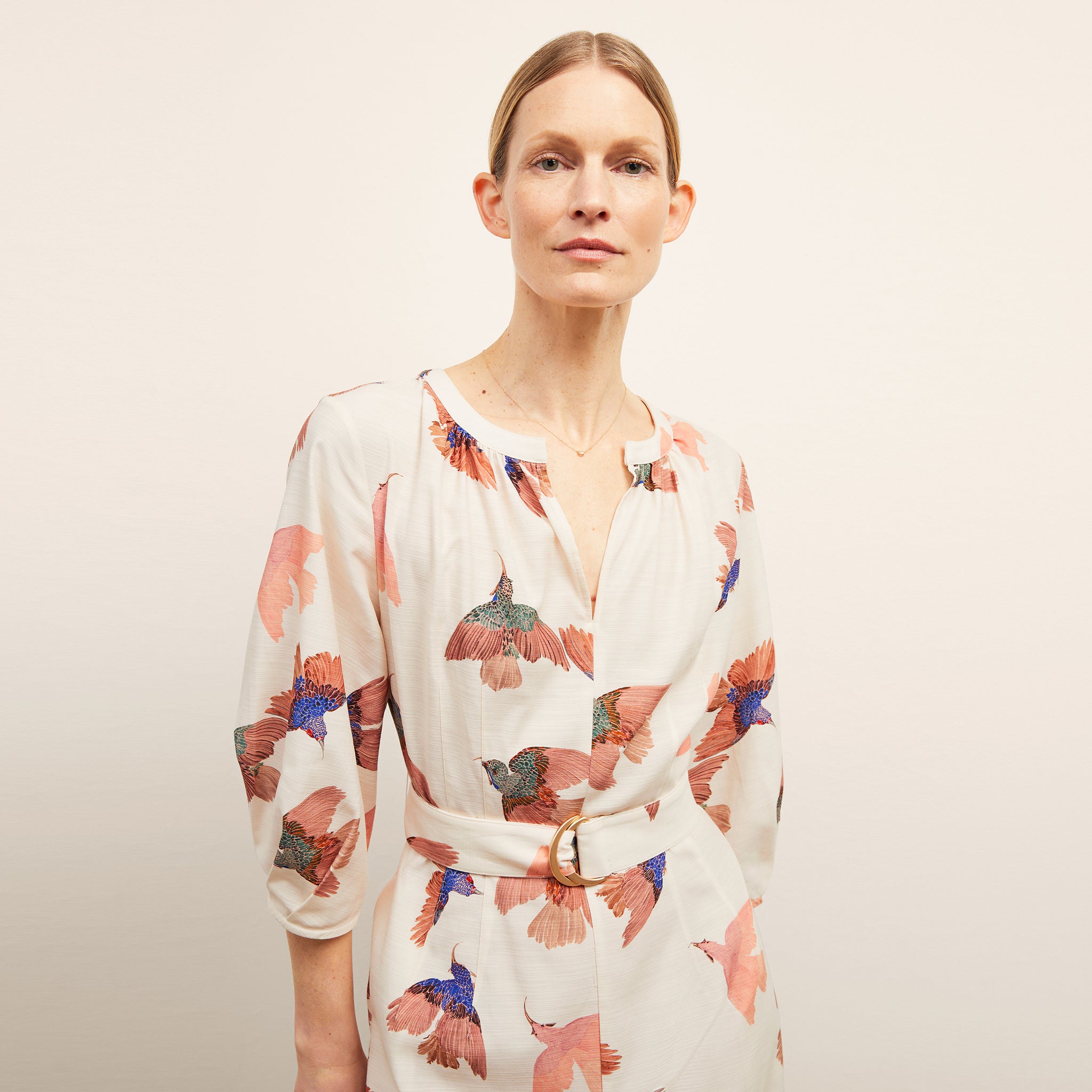 front image of a woman wearing the tessie dress in hummingbird print