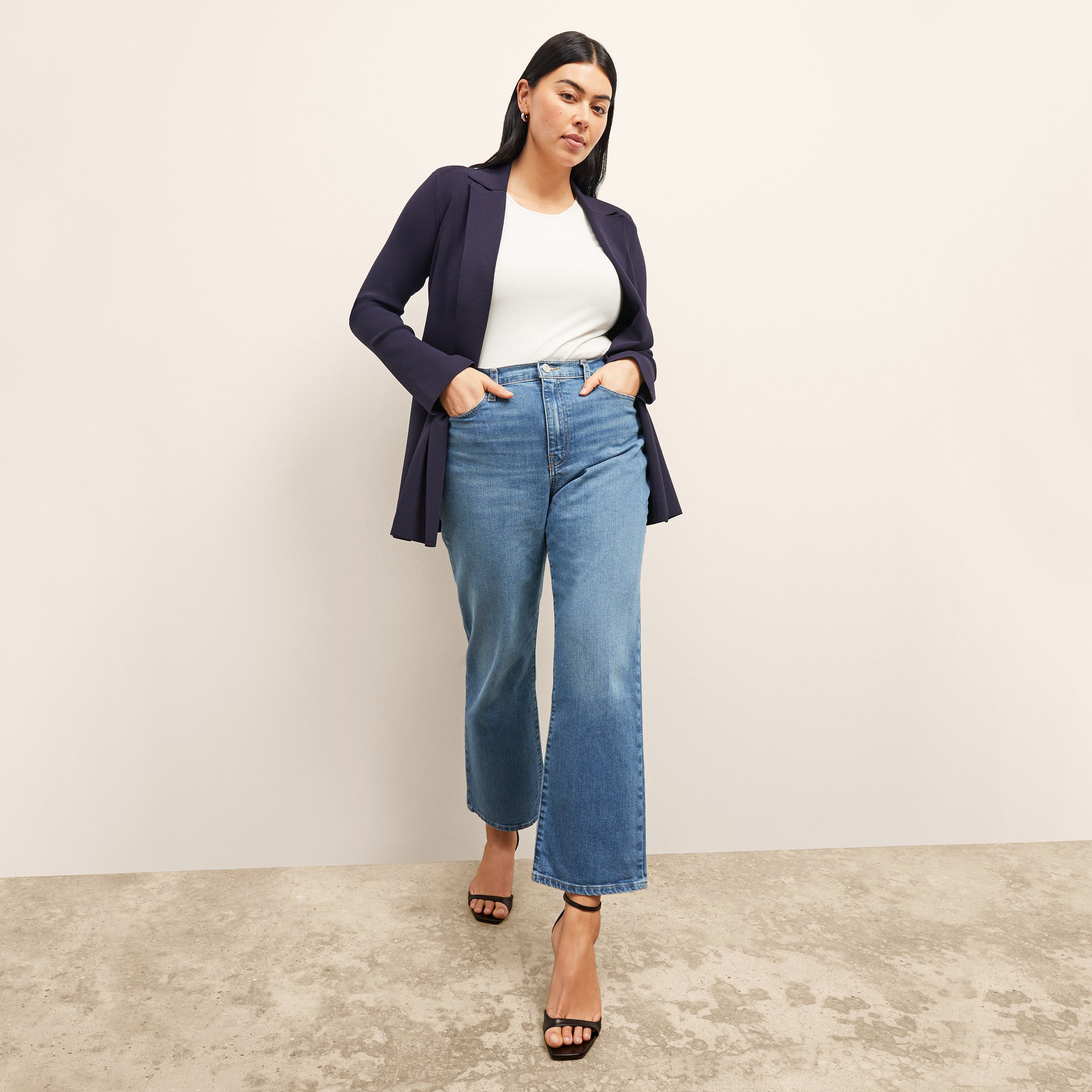 Front image of a woman standing wearing the paige top in fine ribbed cotton in ivory