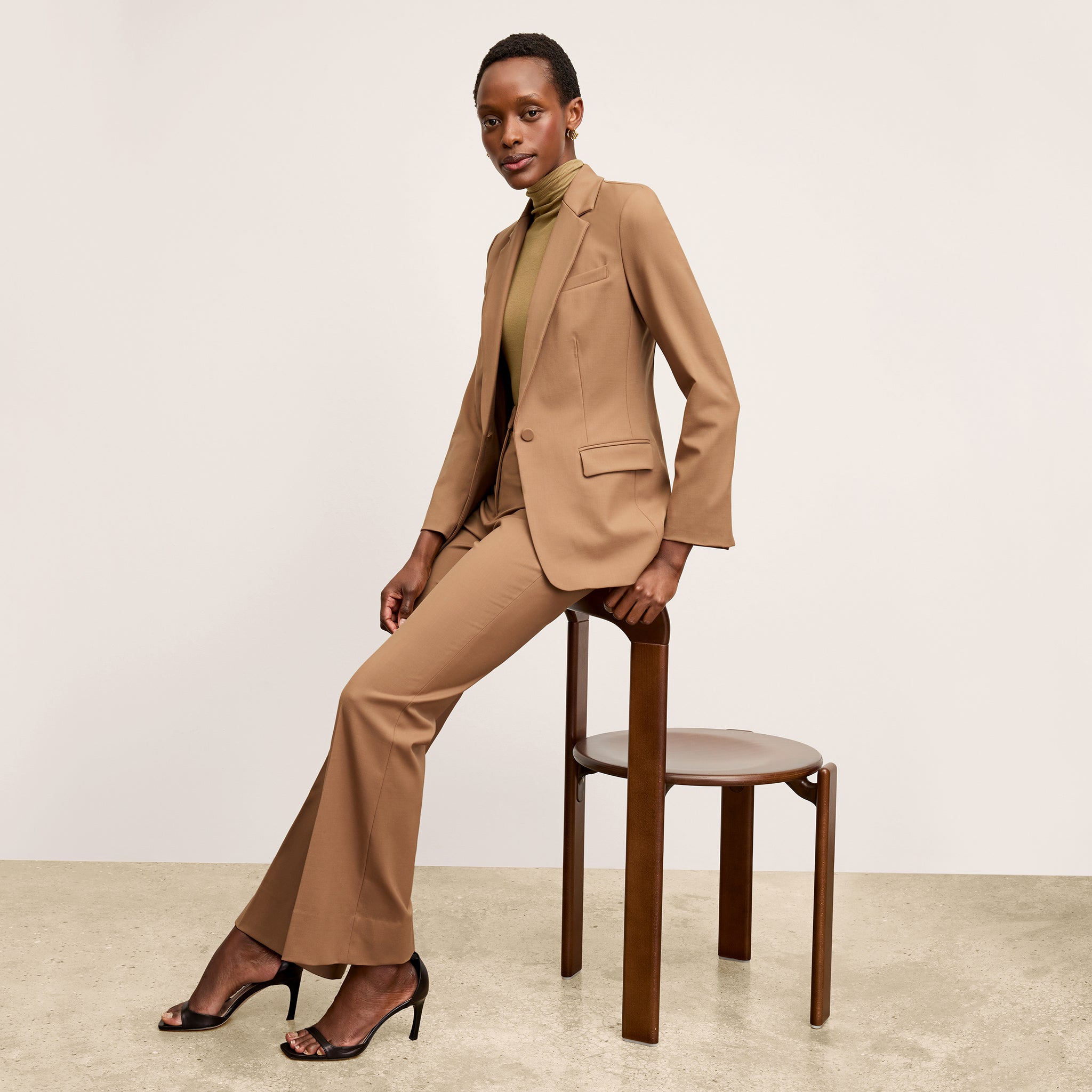 Front image of a woman standing wearing the Yiyan Blazer in Camel