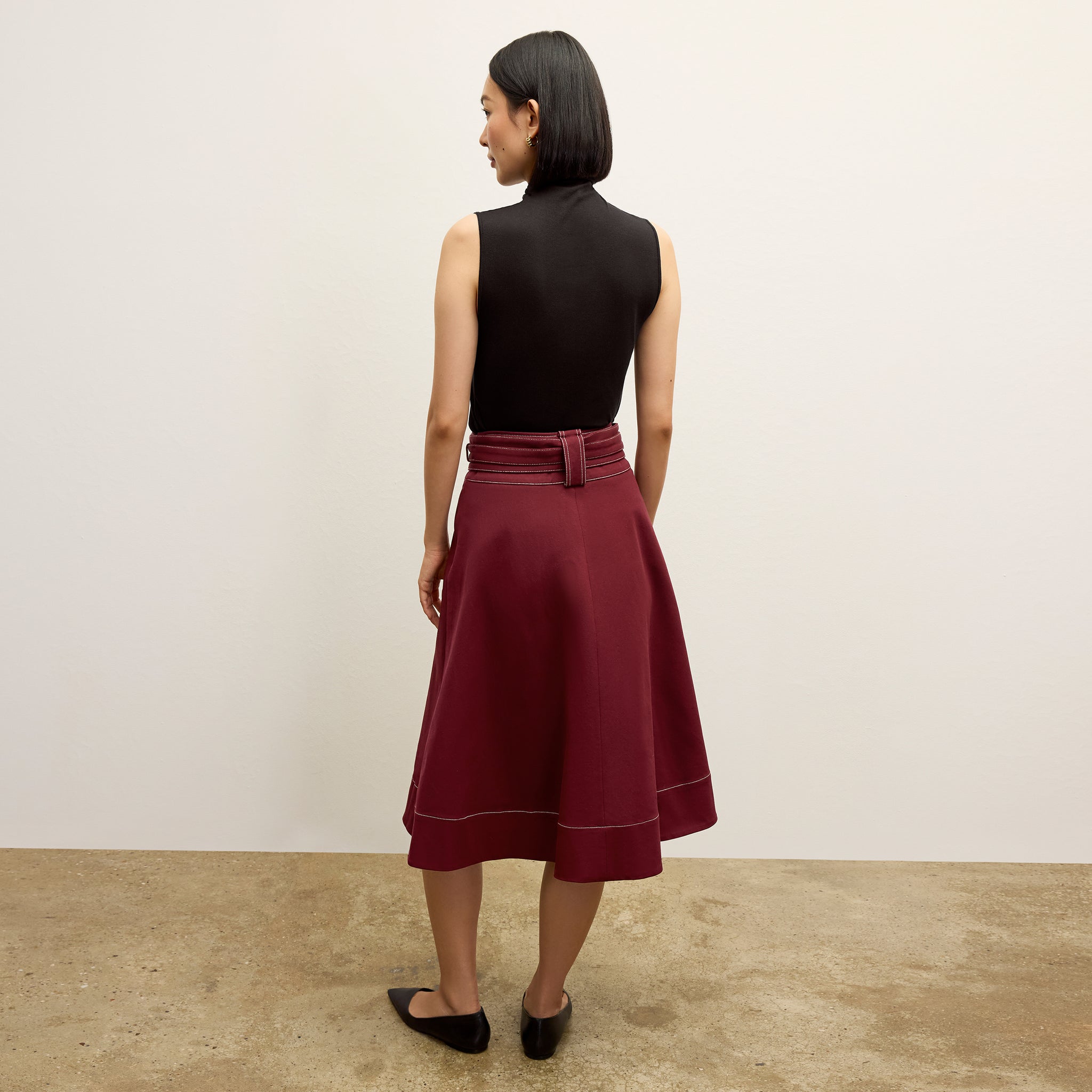back image of a woman wearing the bodhi skirt in berry jam 