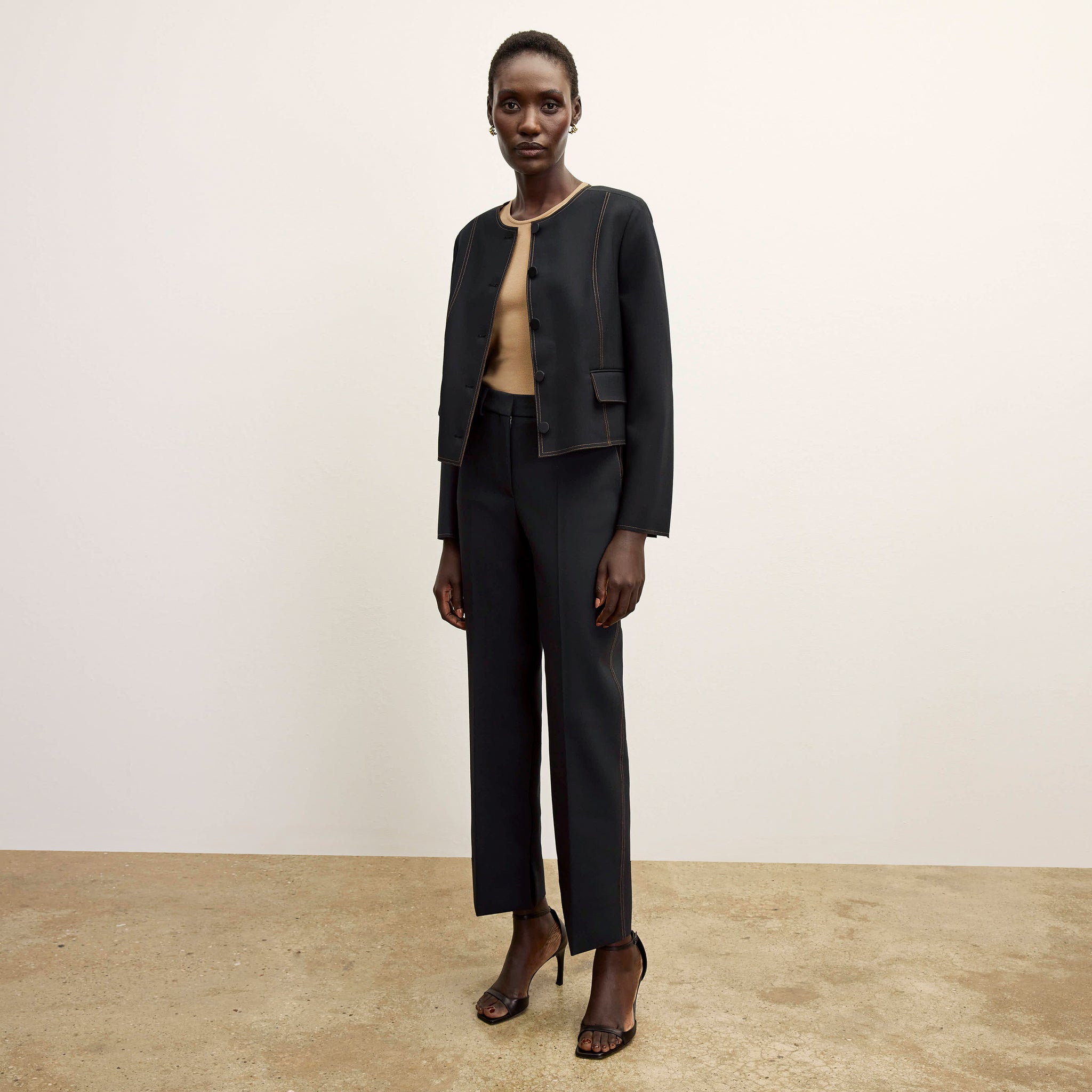 front image of a woman wearing the sella pant in black/light saddle