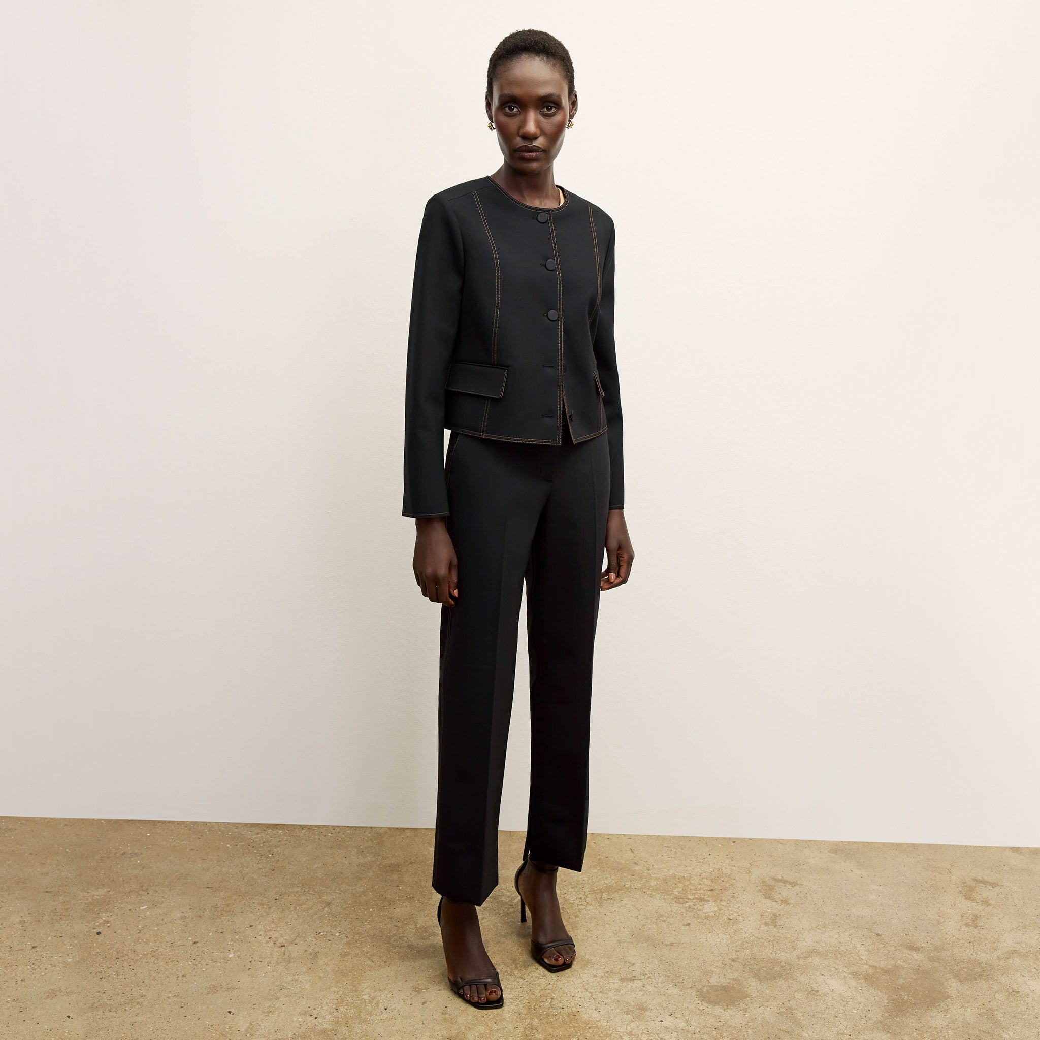 front image of a woman wearing the sella pant in black/light saddle