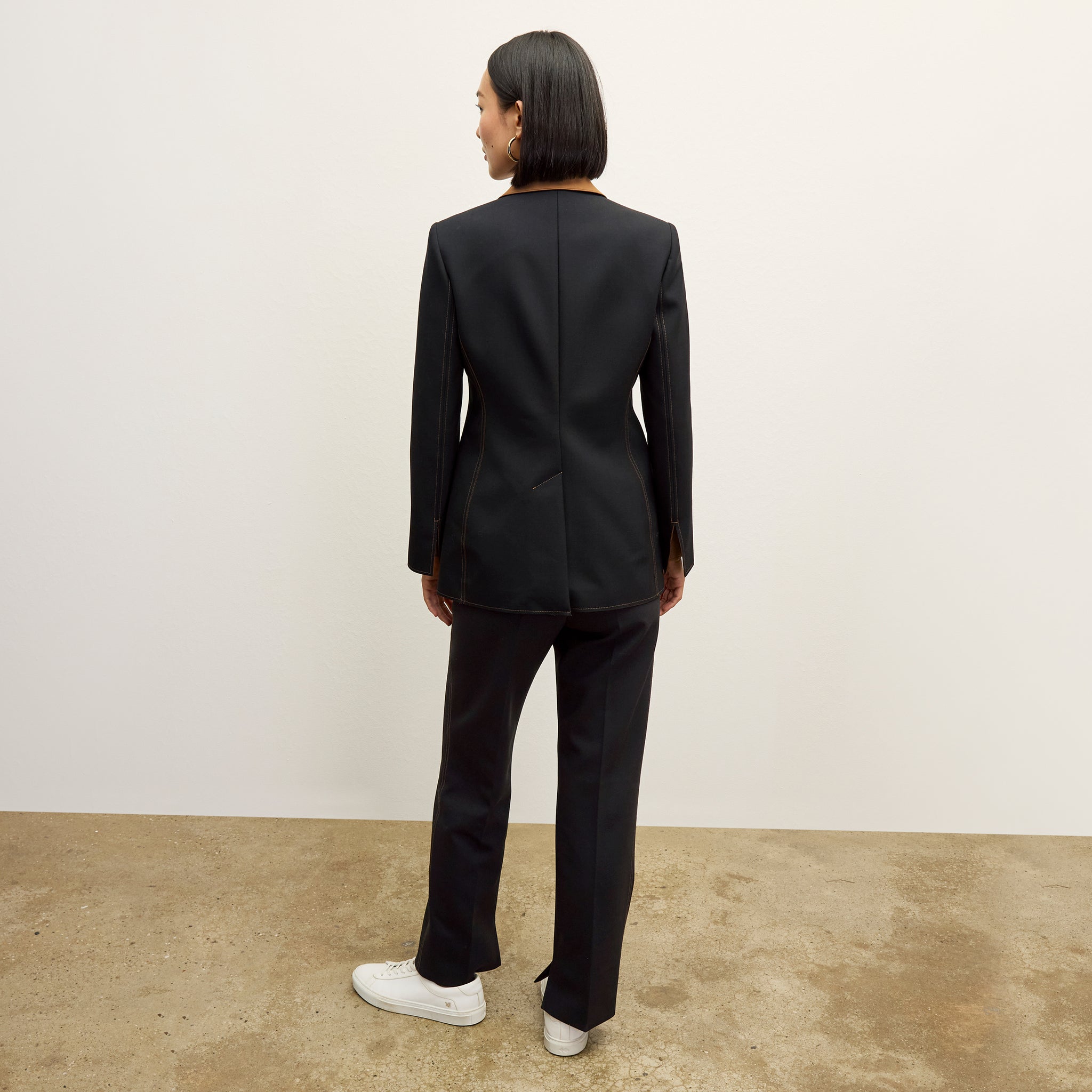 back image of a woman wearing the sella pant in black/light saddle