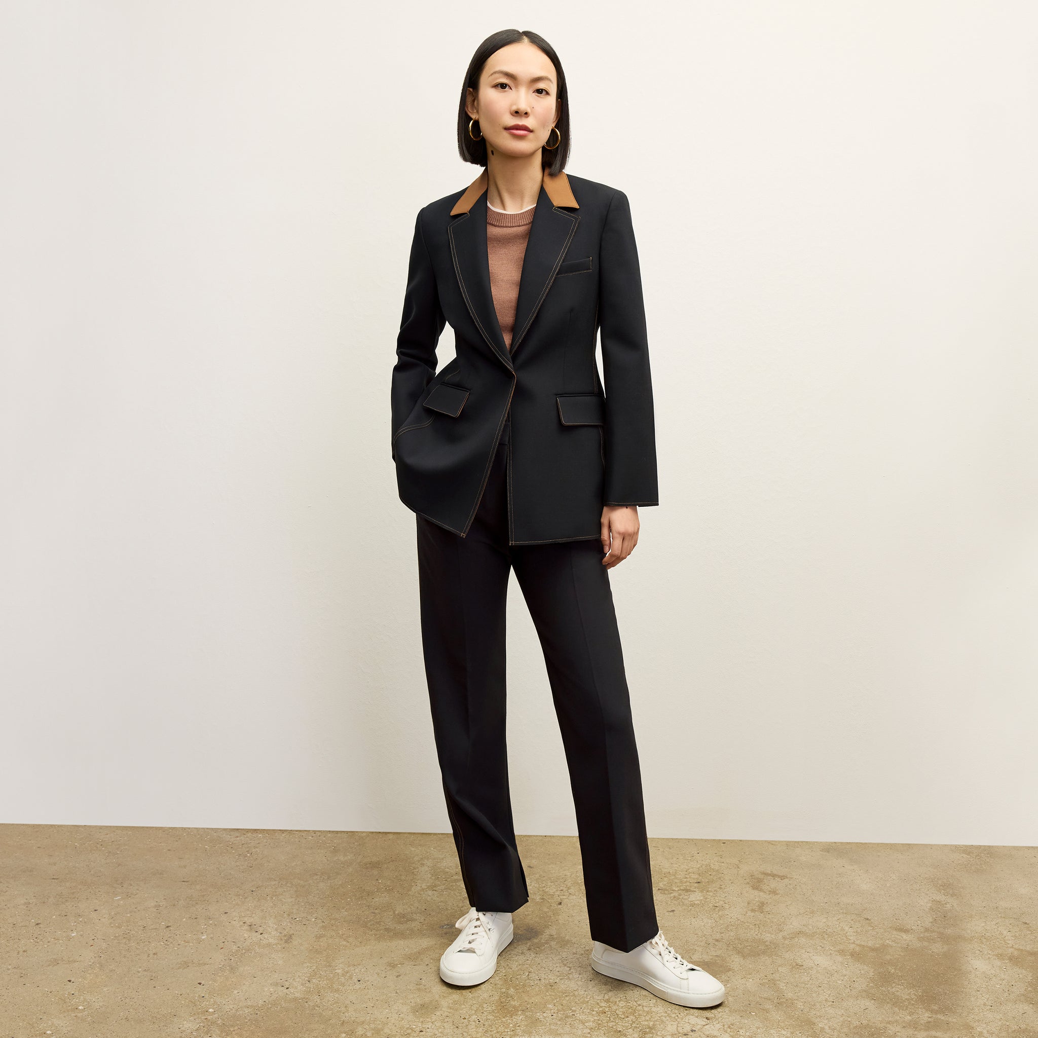 front image of a woman wearing the sella pant in black/light saddle