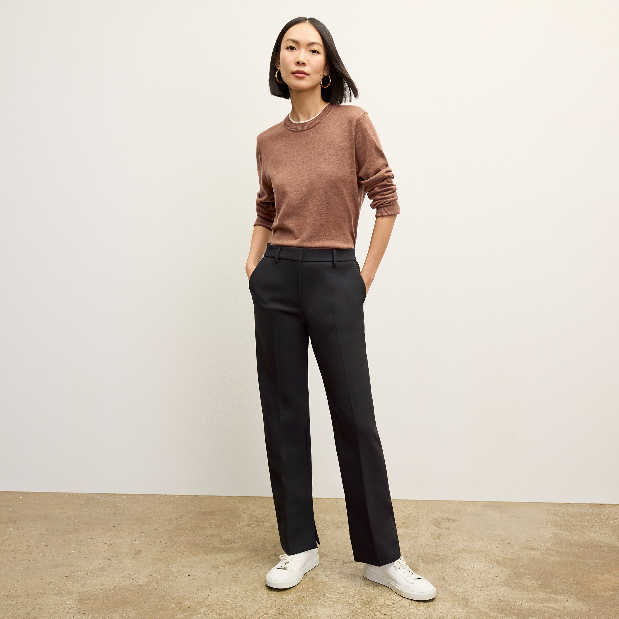 front image of a woman wearing the sella pant in black/light saddle 