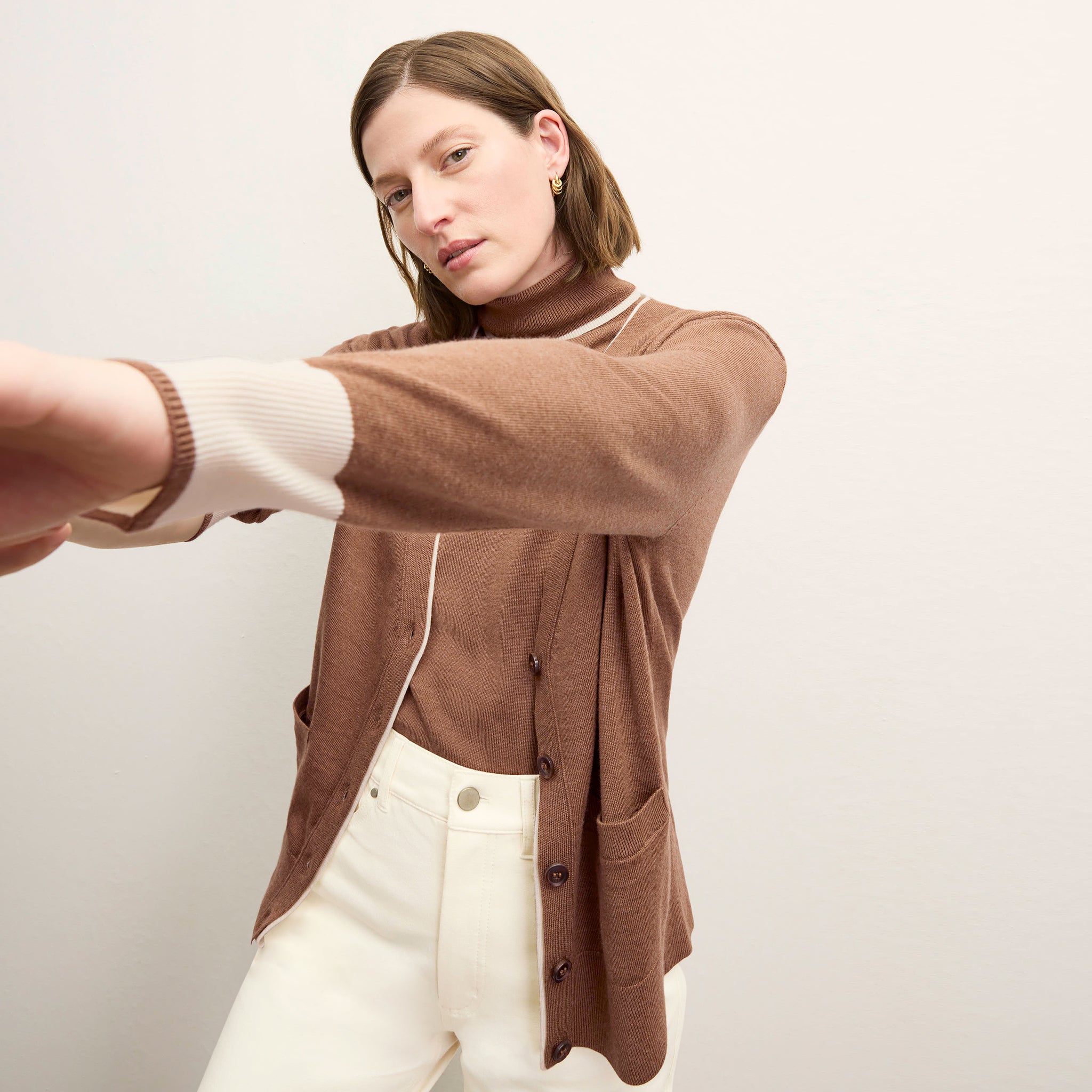 front image of a woman wearing the cookie cardigan in camel/ivory