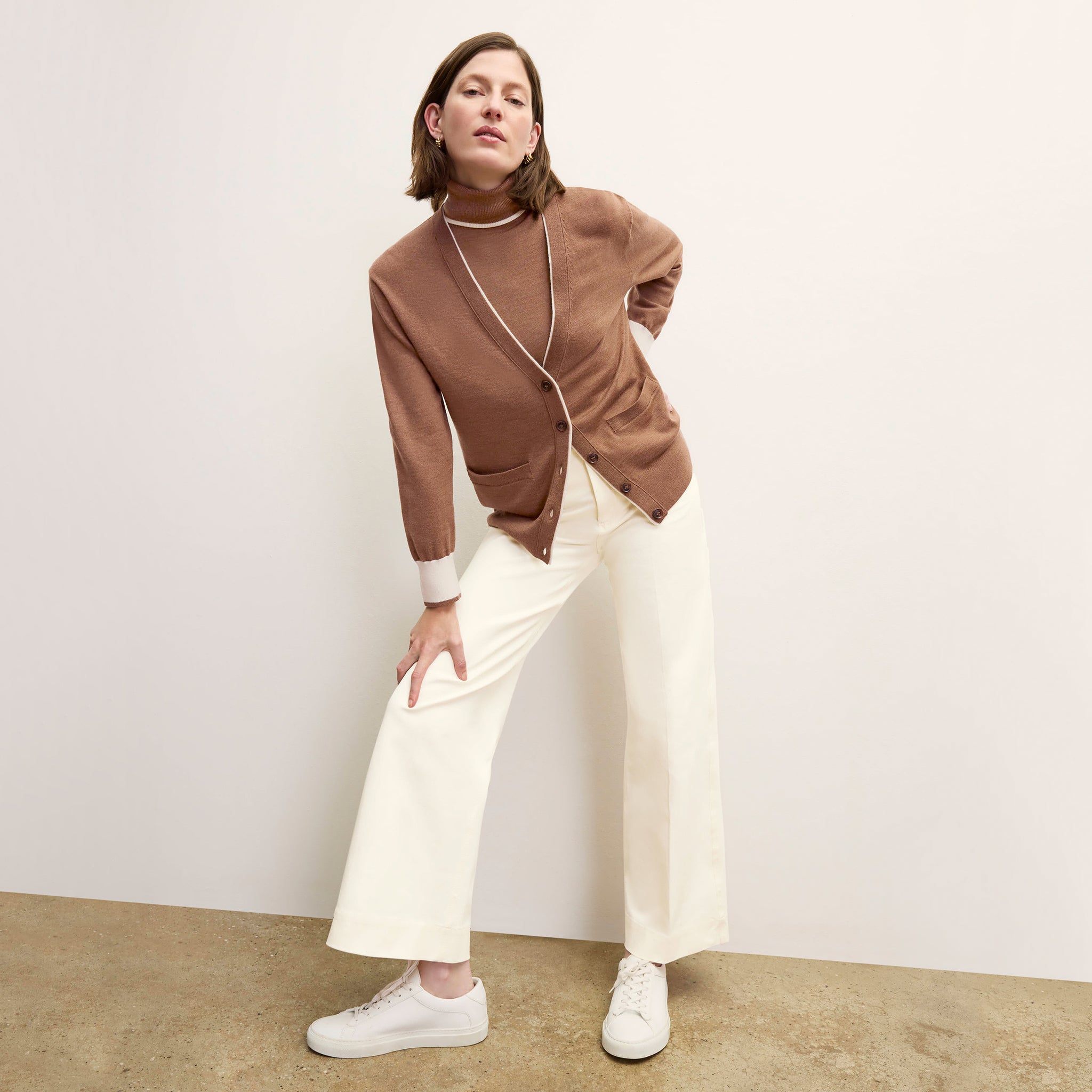 front image of a woman wearing the cookie cardigan in camel/ivory 