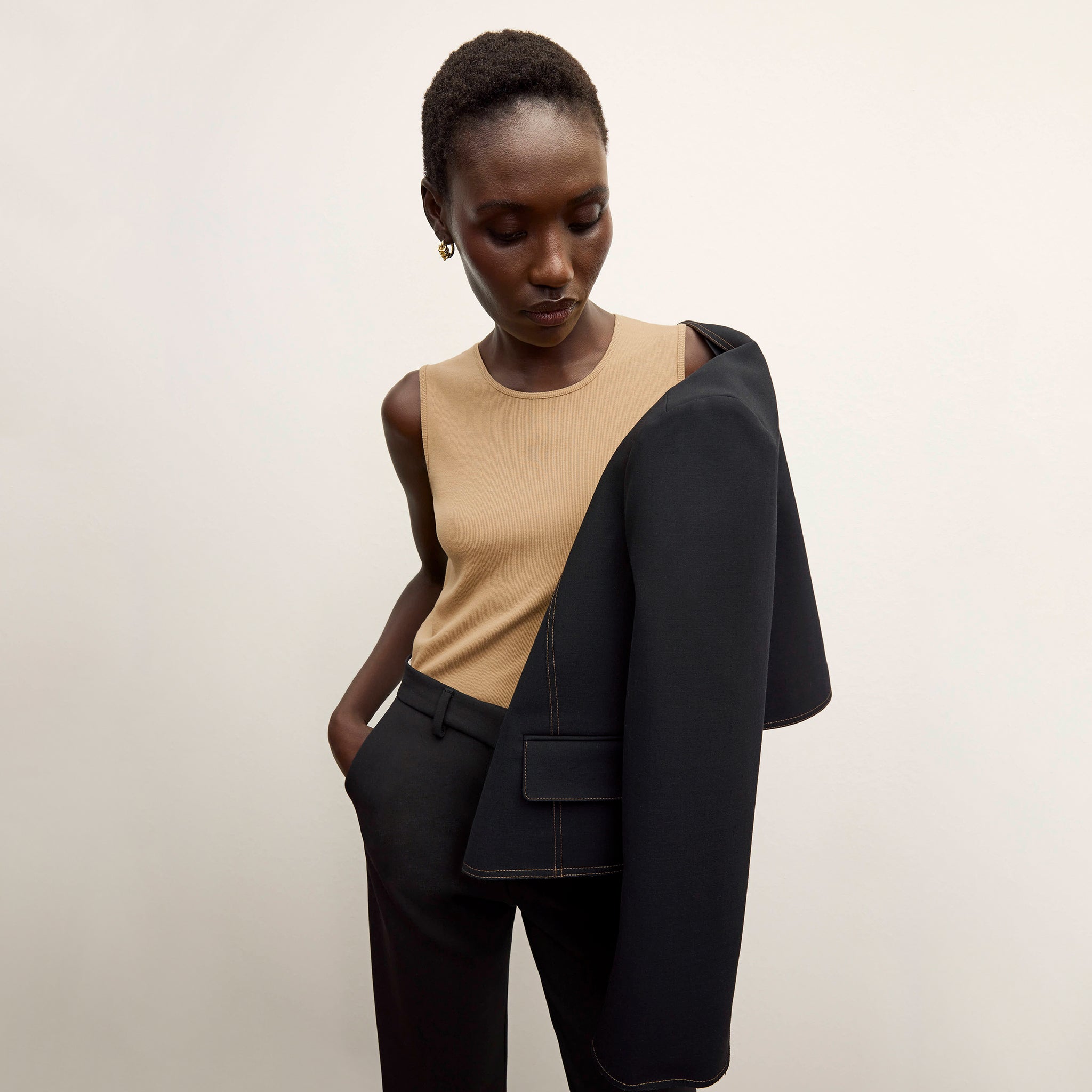 Front image of a woman standing wearing the Paige T-Shirt—Fine Ribbed Cotton in Camel 