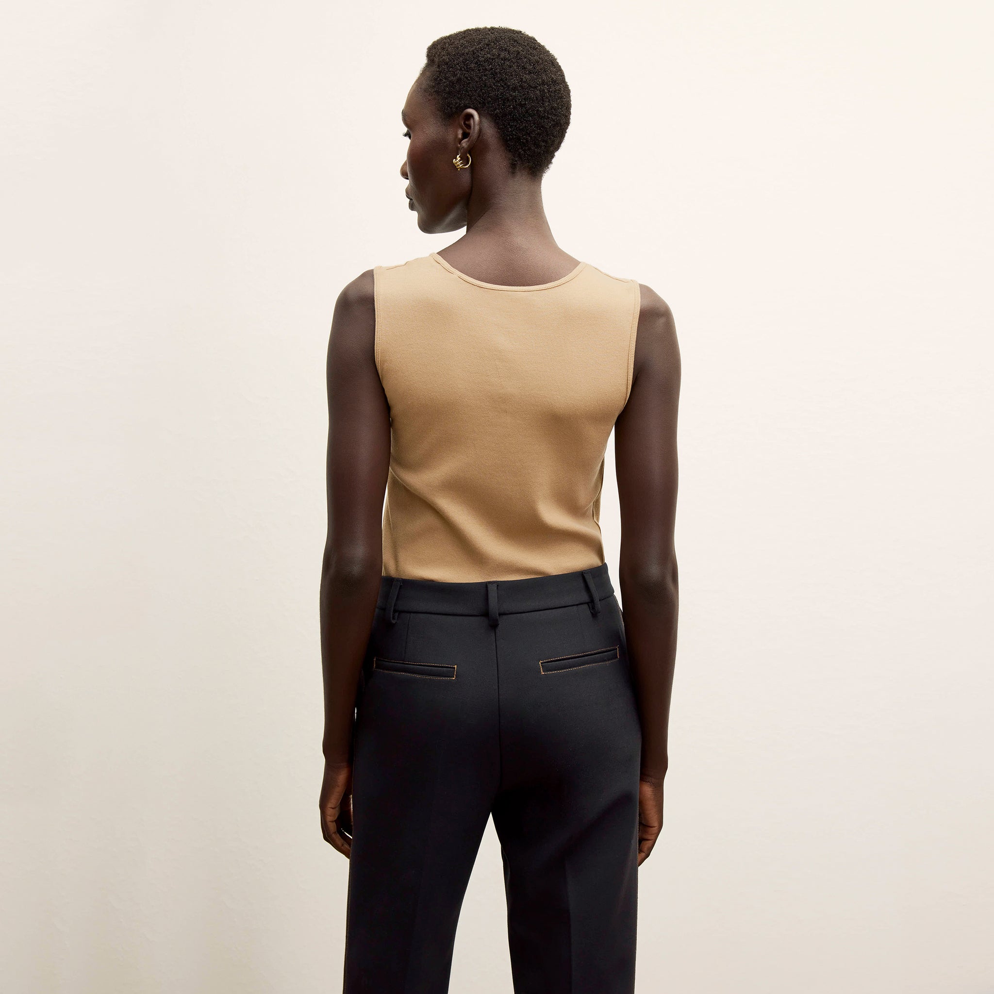 Back image of a woman standing wearing the Paige T-Shirt—Fine Ribbed Cotton in Camel 