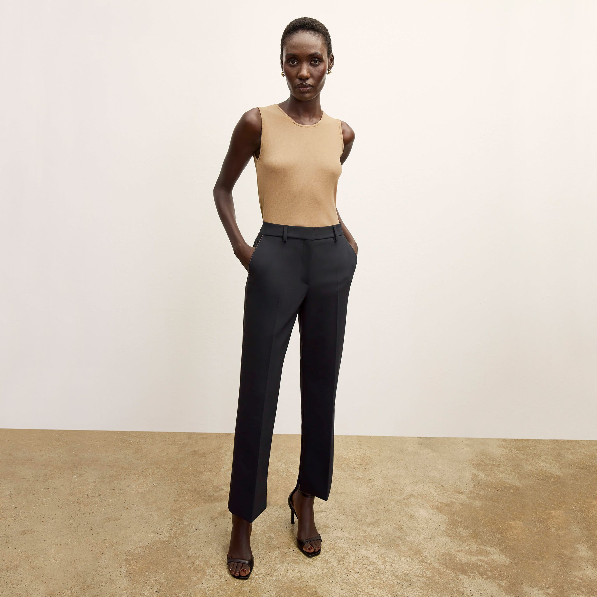 Front image of a woman standing wearing the Paige T-Shirt—Fine Ribbed Cotton in Camel 