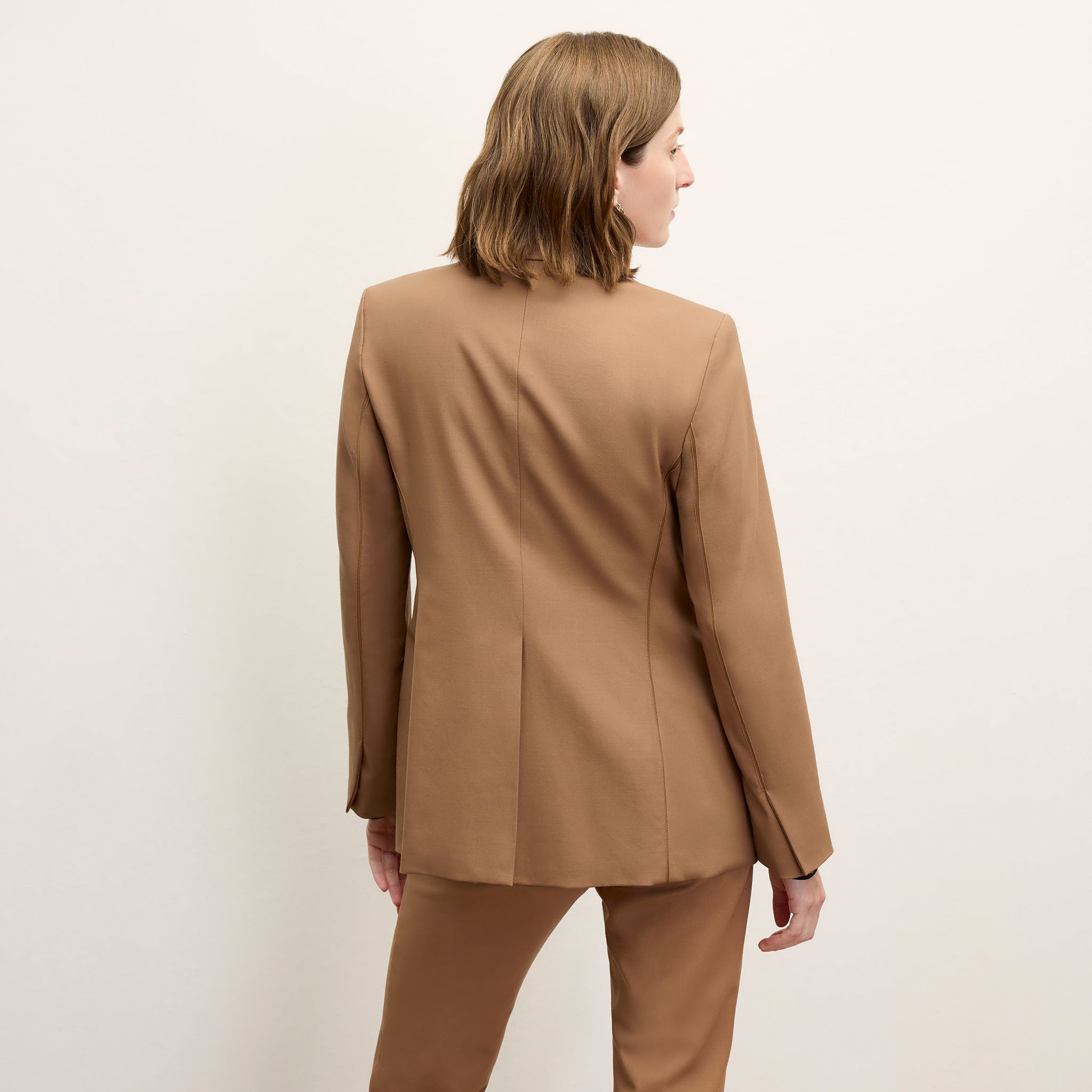 Back image of a woman standing wearing the Yiyan Blazer in Camel 