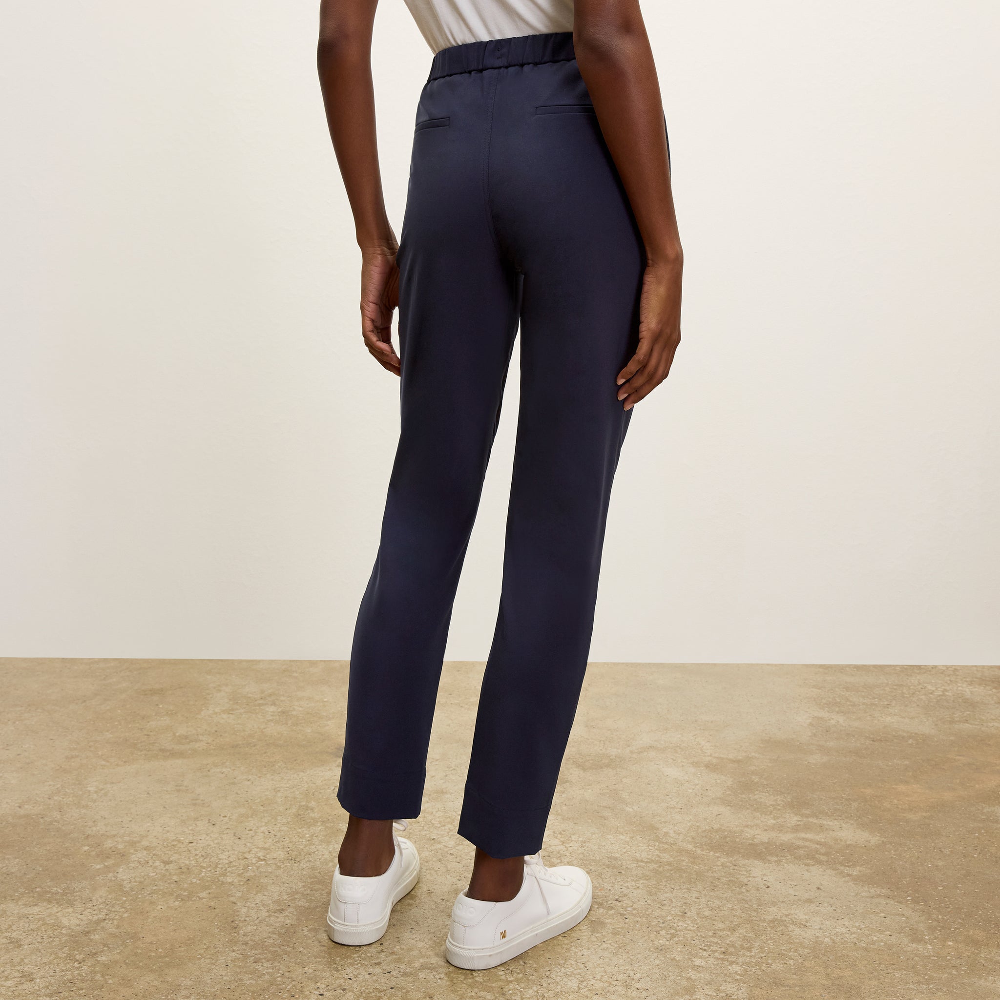 back image of a woman wearing the colby pants in dark navy
