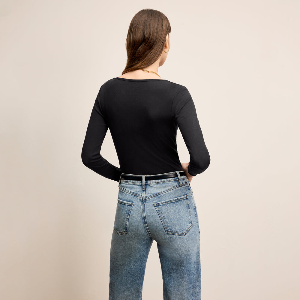 back image of a woman standing wearing the marcia top in fine ribbed cotton in black