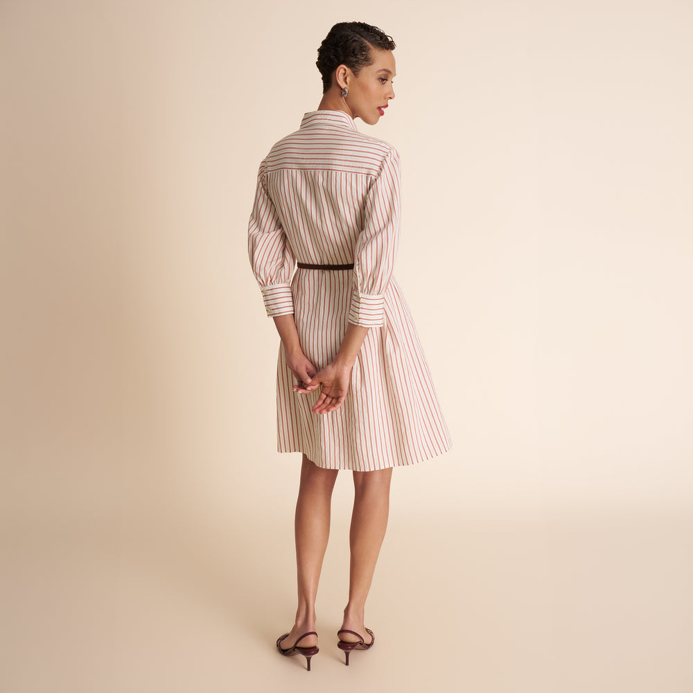 Woman wearing a striped dress on a beige background