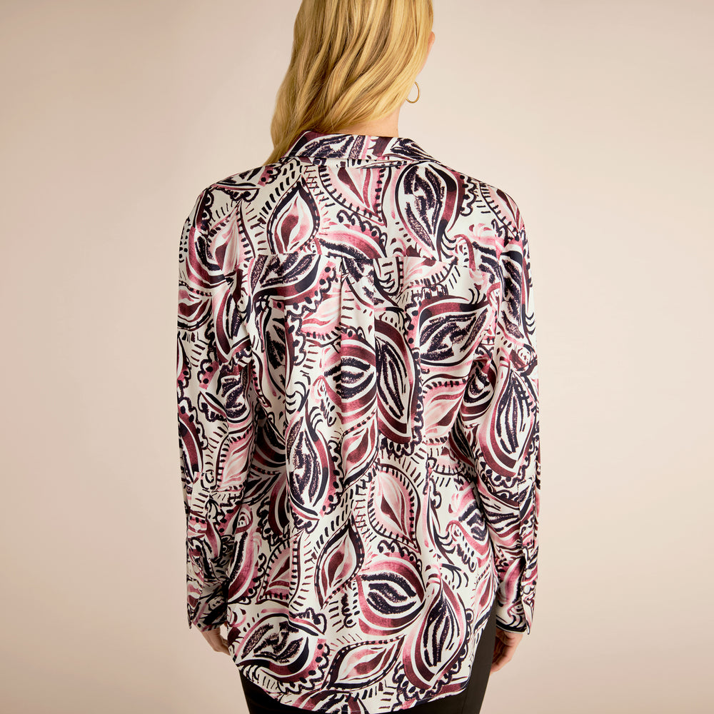 Person wearing a patterned shirt with a neutral background