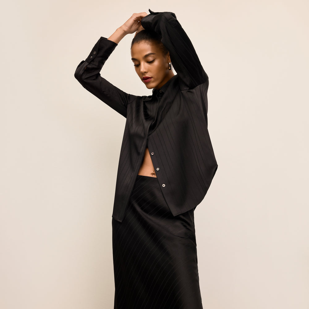 Woman wearing a black dress against a plain background