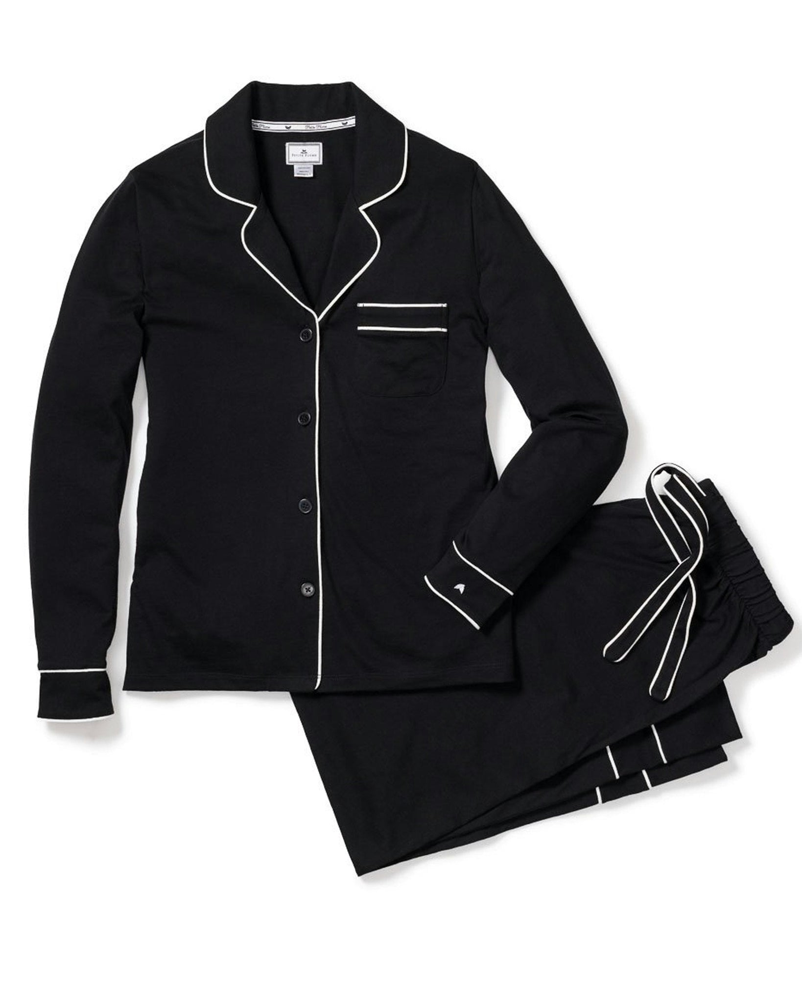 Black pajama set with white piping on a white background