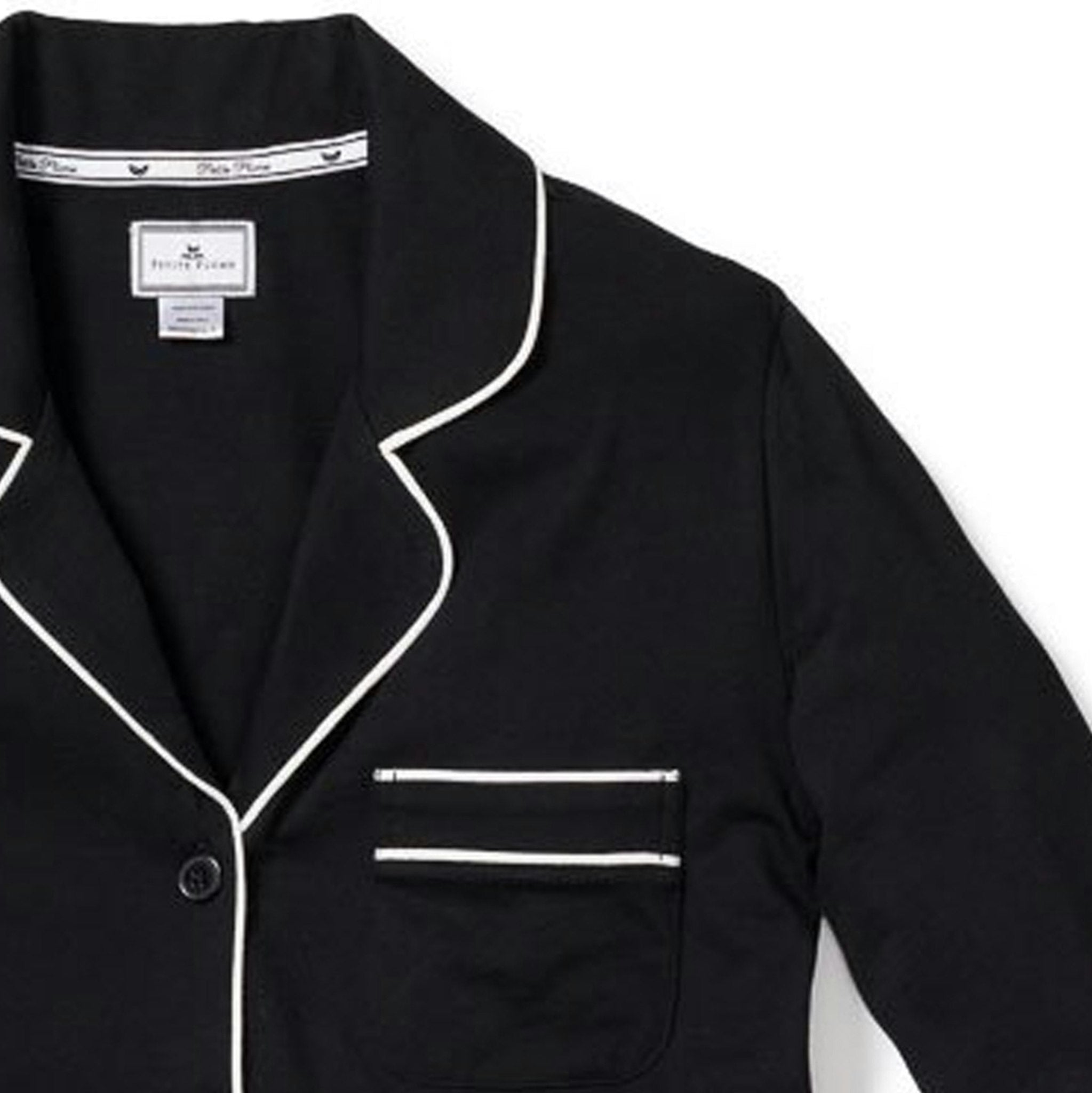 Black pajama top with white piping on a white background