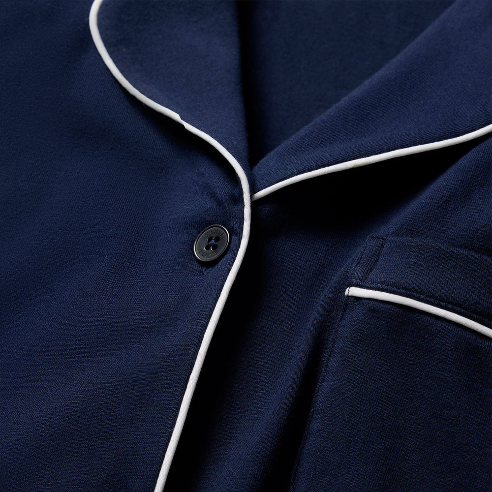Close-up of a navy blue pajama top with white piping