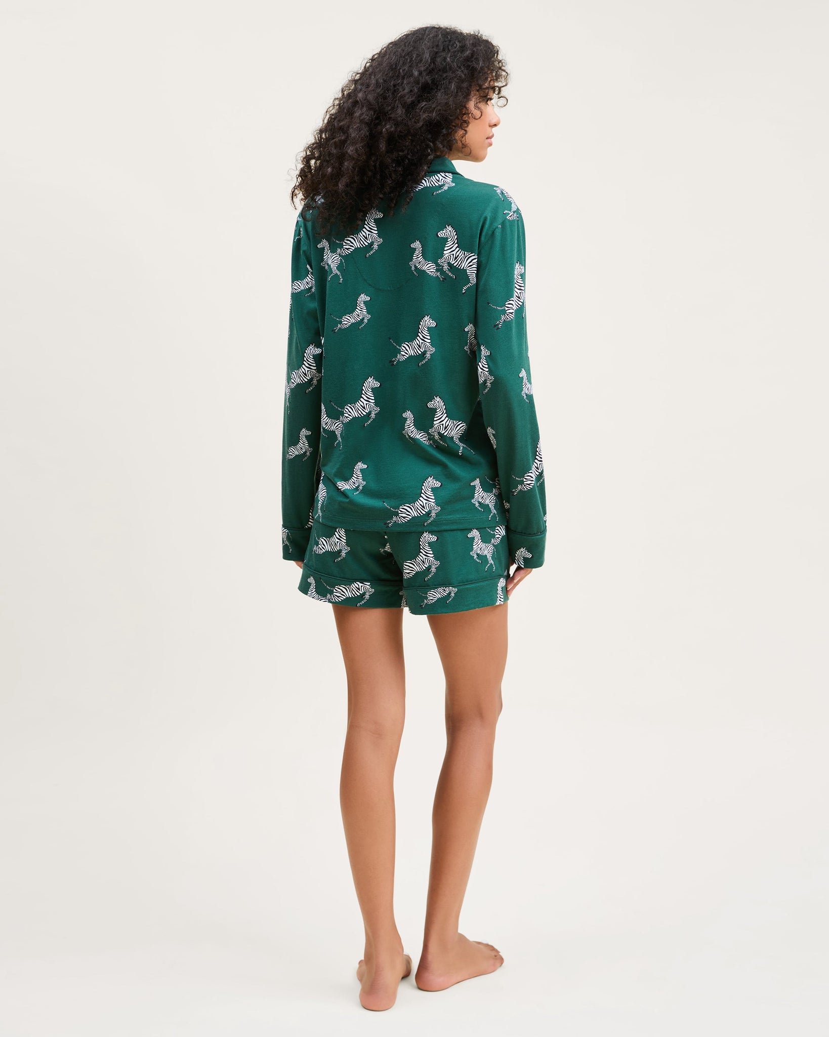 Person wearing a green pajama set with dog pattern on a white background