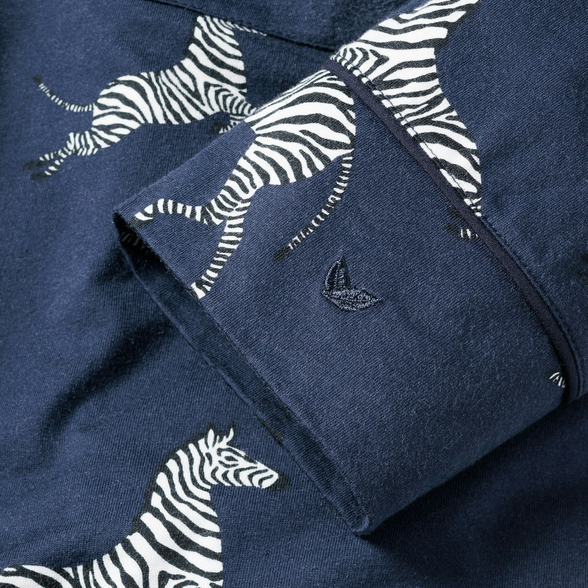 Navy blue fabric with zebra pattern and a brand logo.