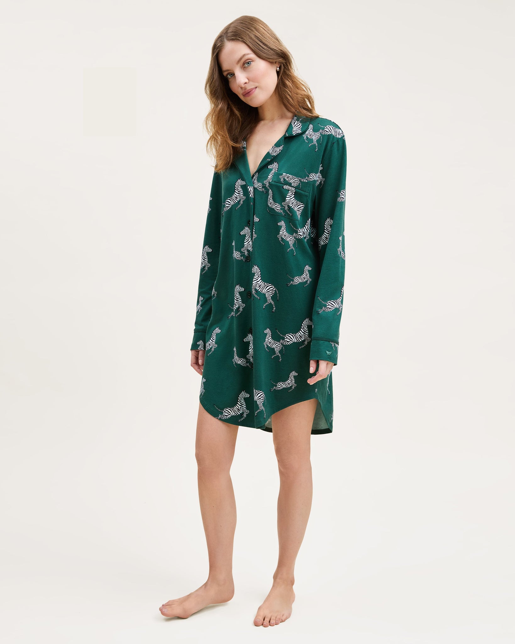Woman wearing a green nightshirt with a pattern on a white background