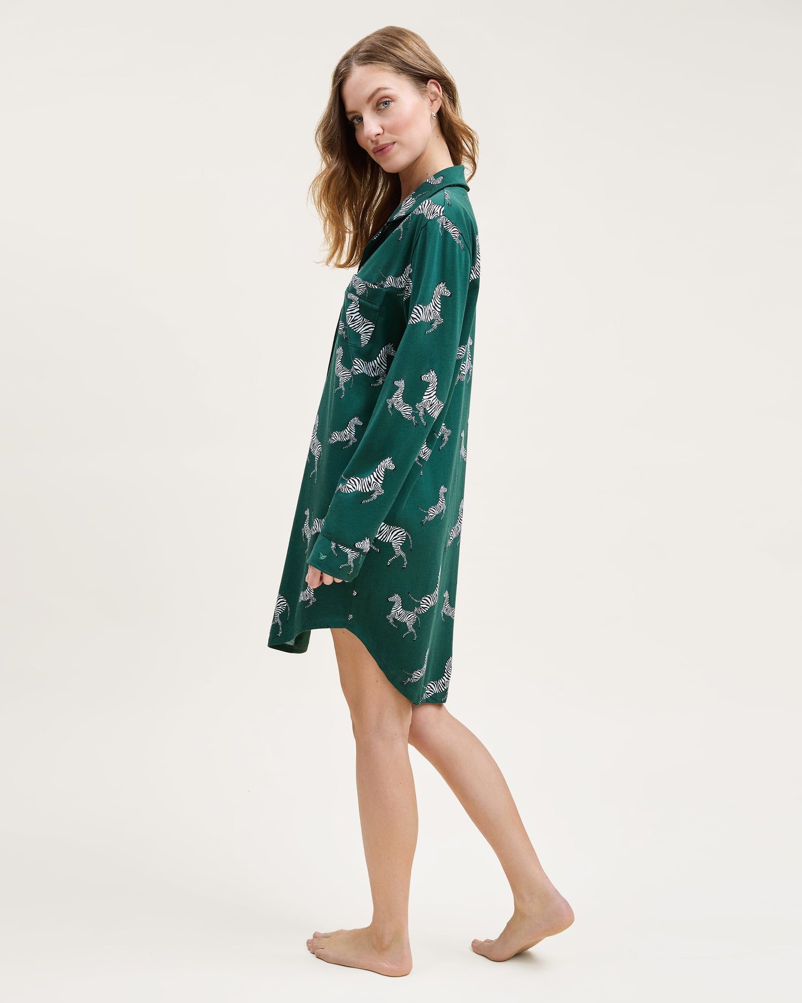 Woman wearing a green nightshirt with animal pattern on a white background