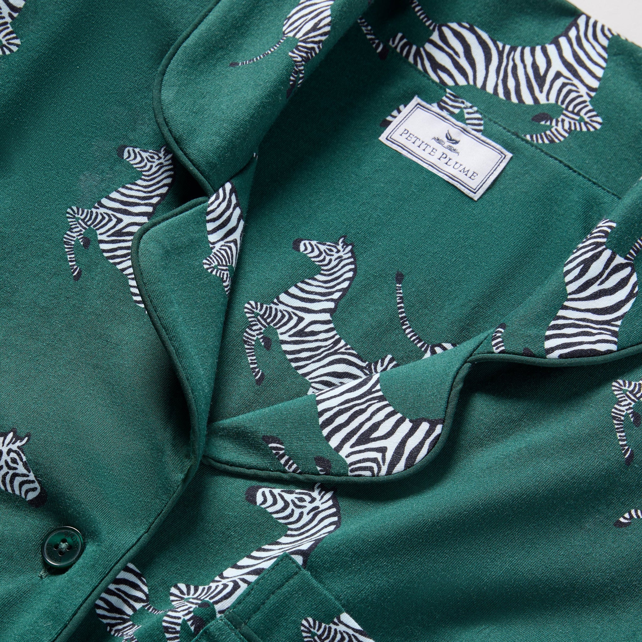 Green shirt with zebra pattern and a visible brand label.