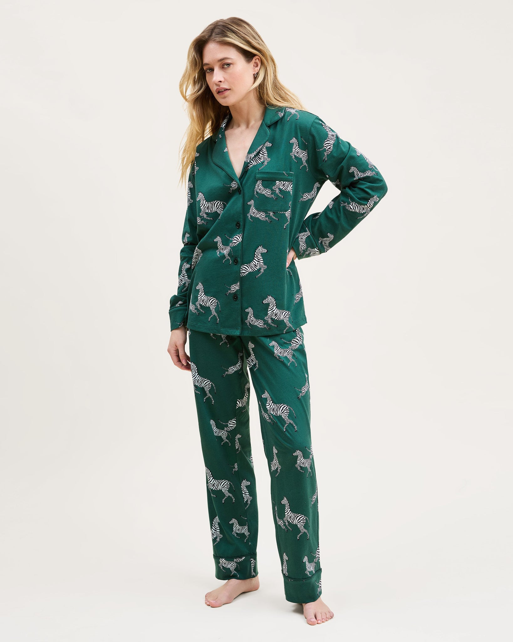 Woman wearing green pajamas with animal pattern on a white background 