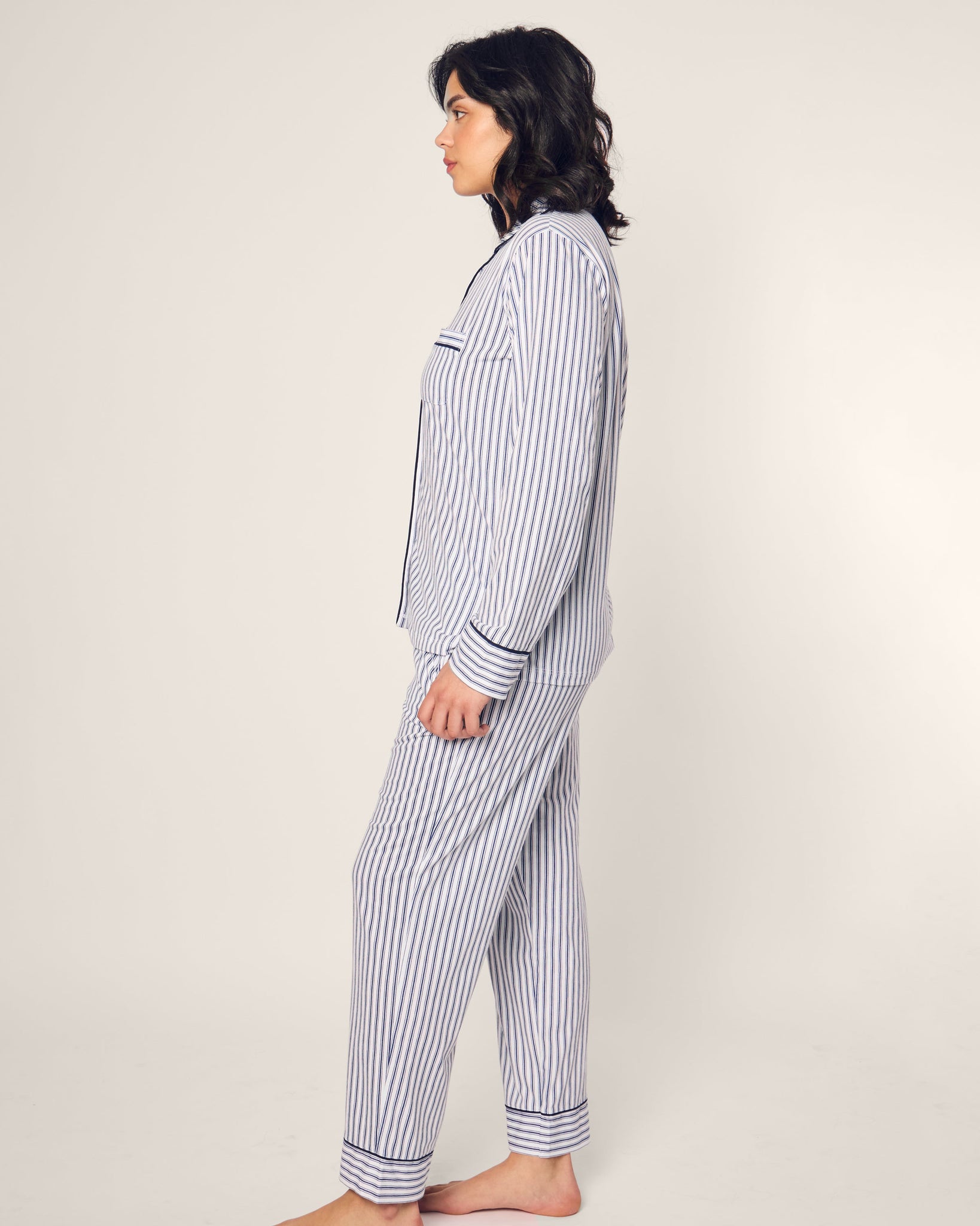 Person wearing a striped pajama set on a plain background