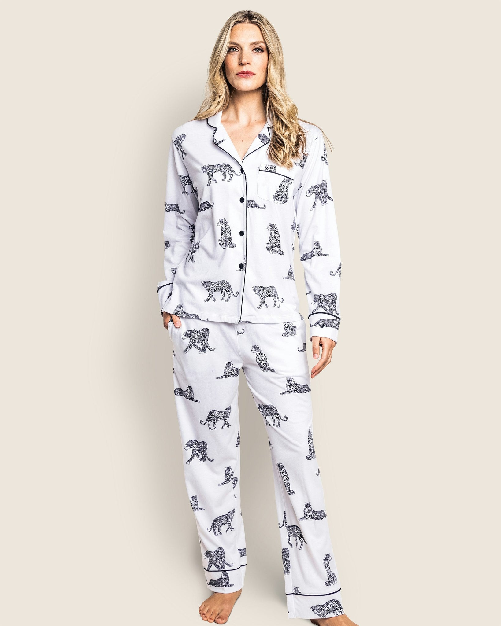 Woman wearing a light blue pajama set with animal prints on a beige background 