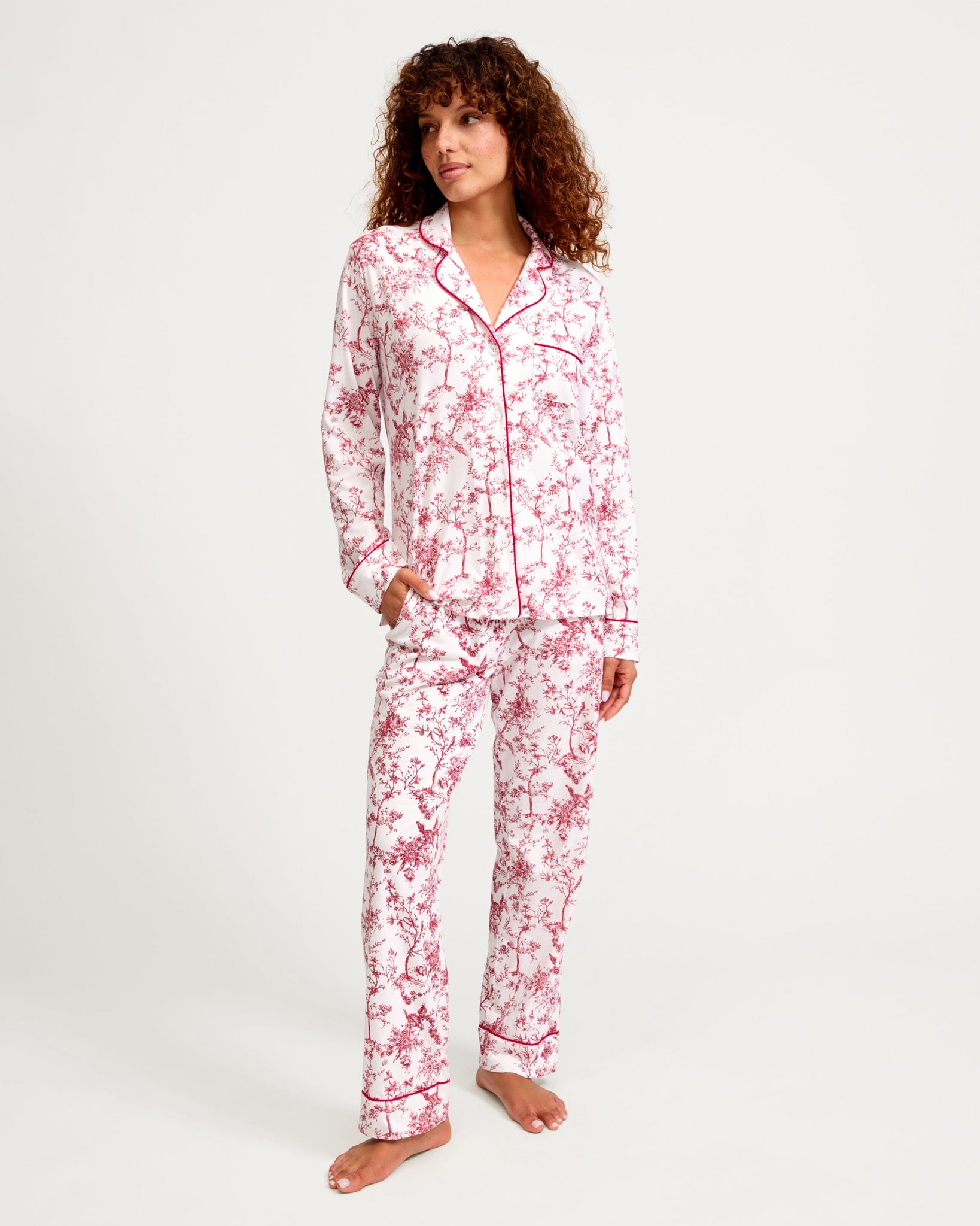 Woman wearing a pink floral pajama set on a white background 
