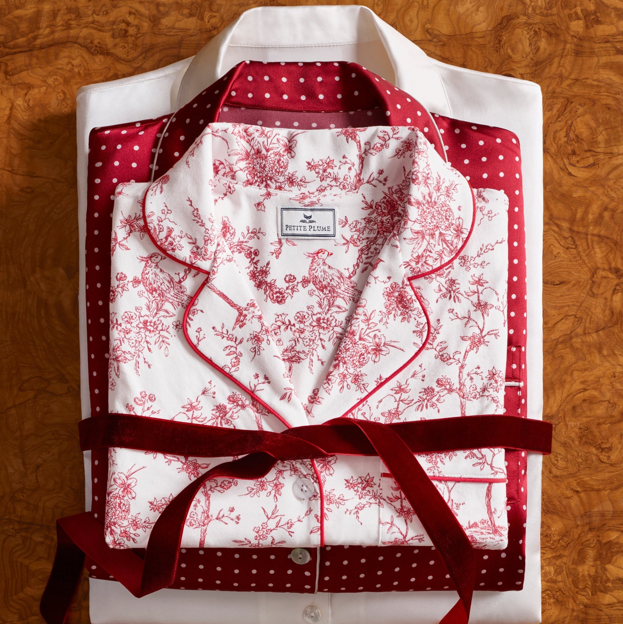 White shirt with red floral pattern and red ribbon on a wooden surface