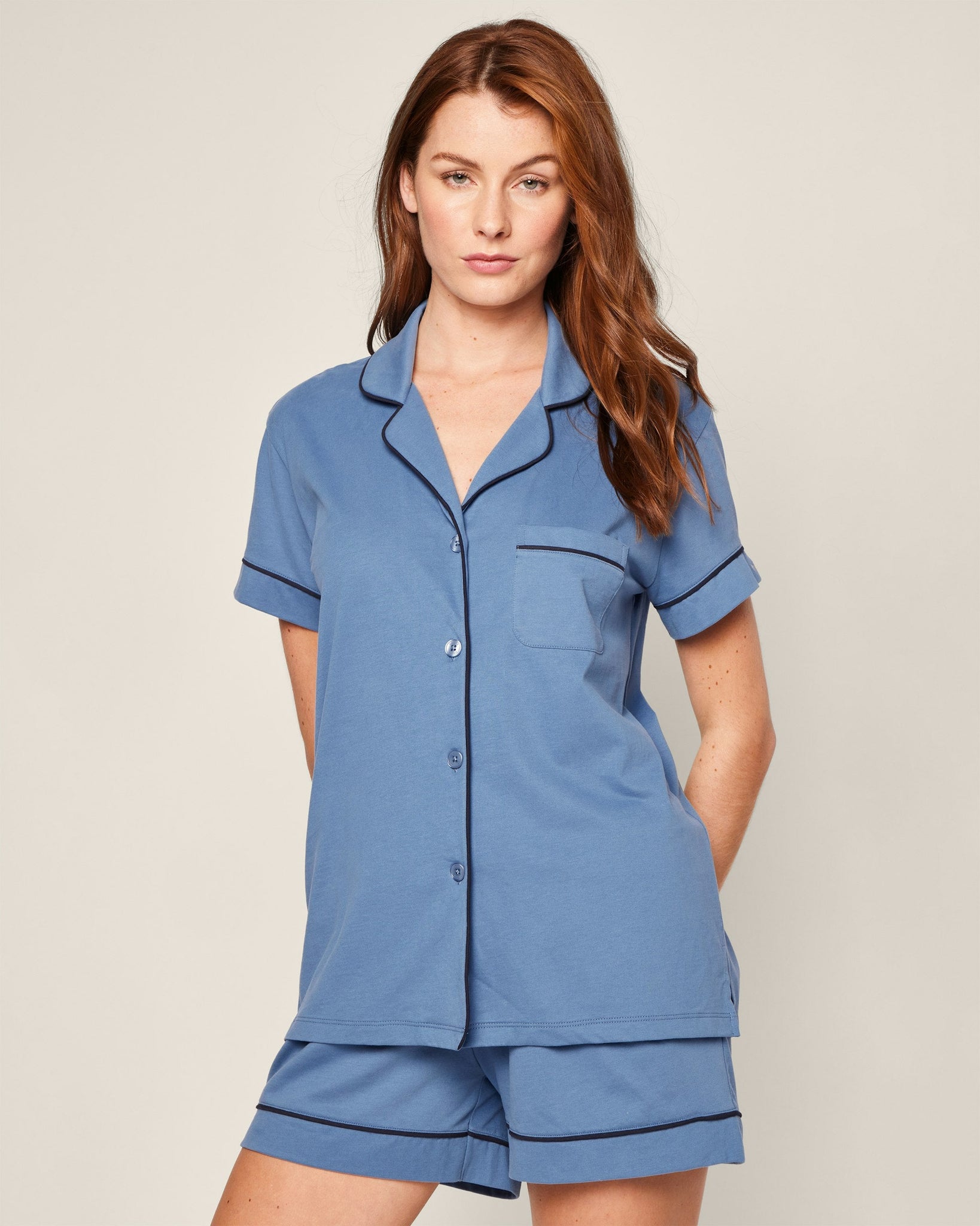 Woman wearing a blue pajama set against a plain background