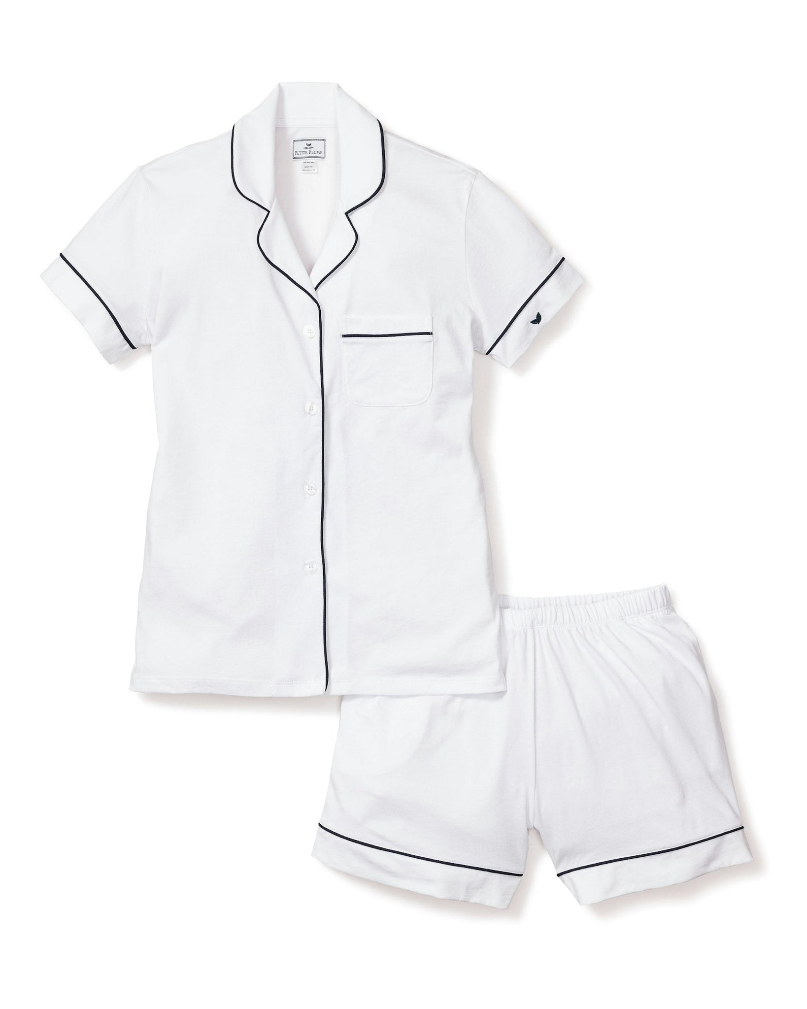 White pajama set with black piping on a white background