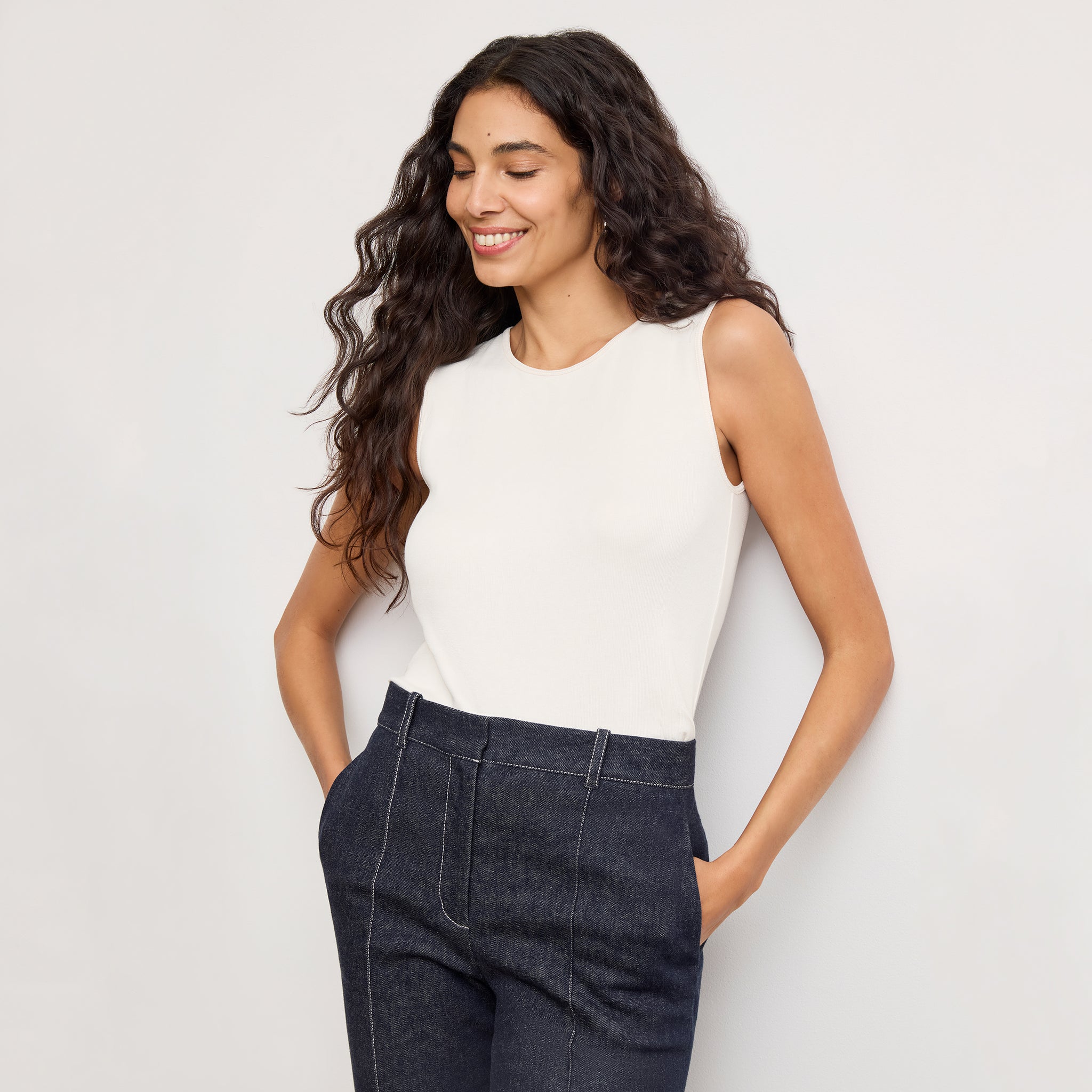 Front image of a woman standing wearing the paige top in fine ribbed cotton in ivory