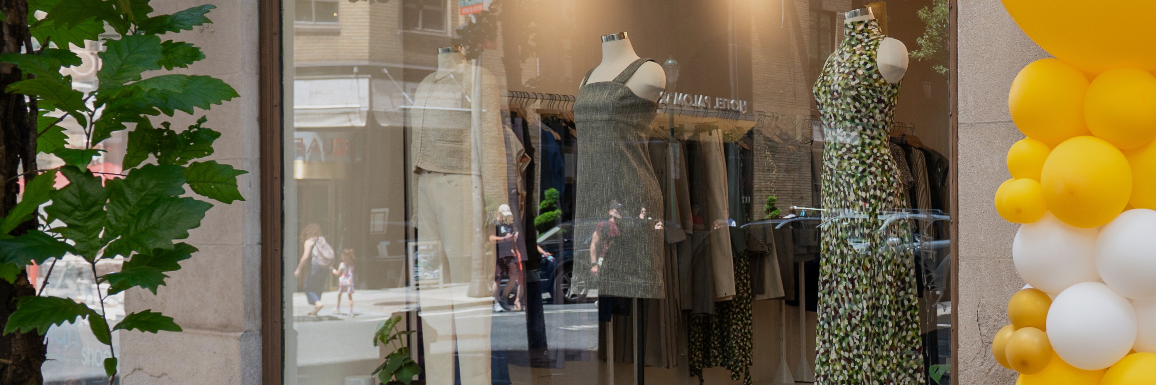 Store window display with mannequins and clothing, blurred background