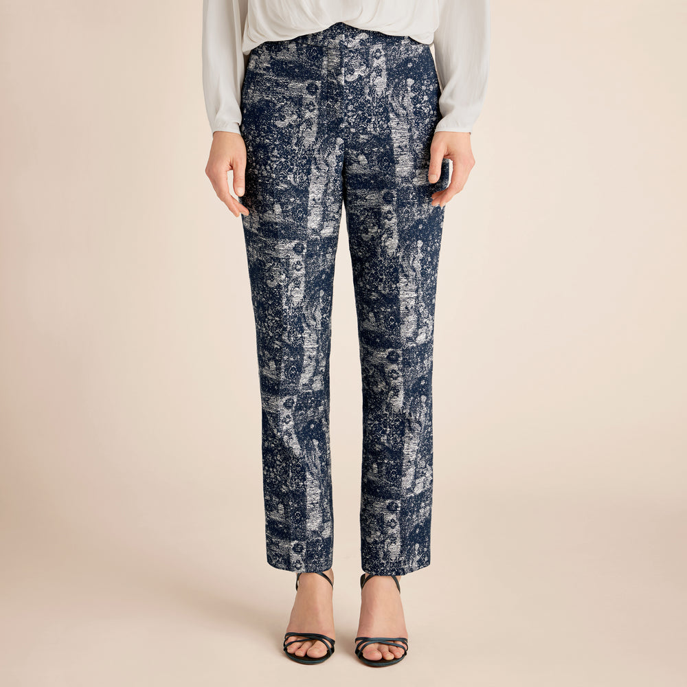 Person wearing blue patterned pants on a beige background
