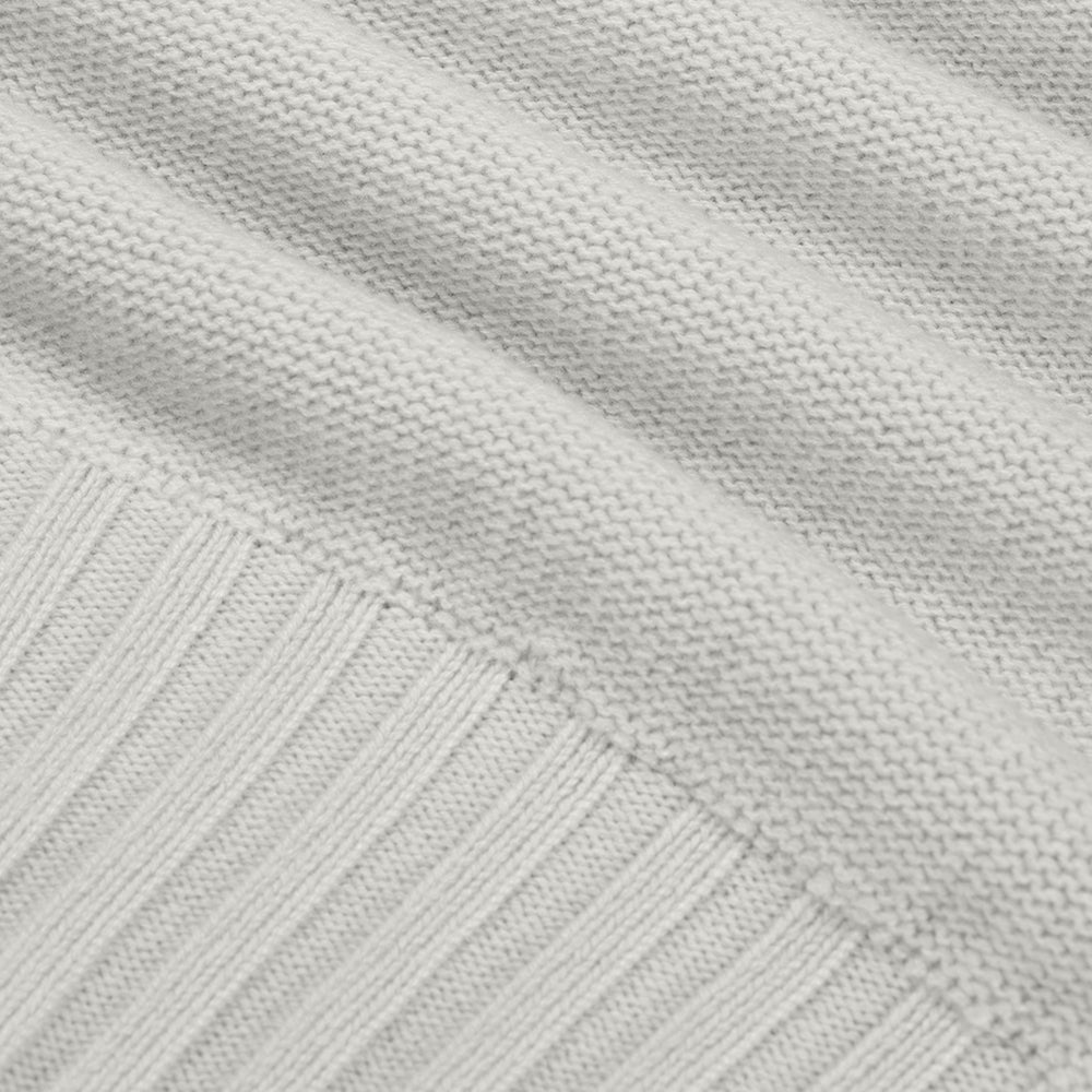 Close-up of a textured light gray fabric with a subtle pattern.