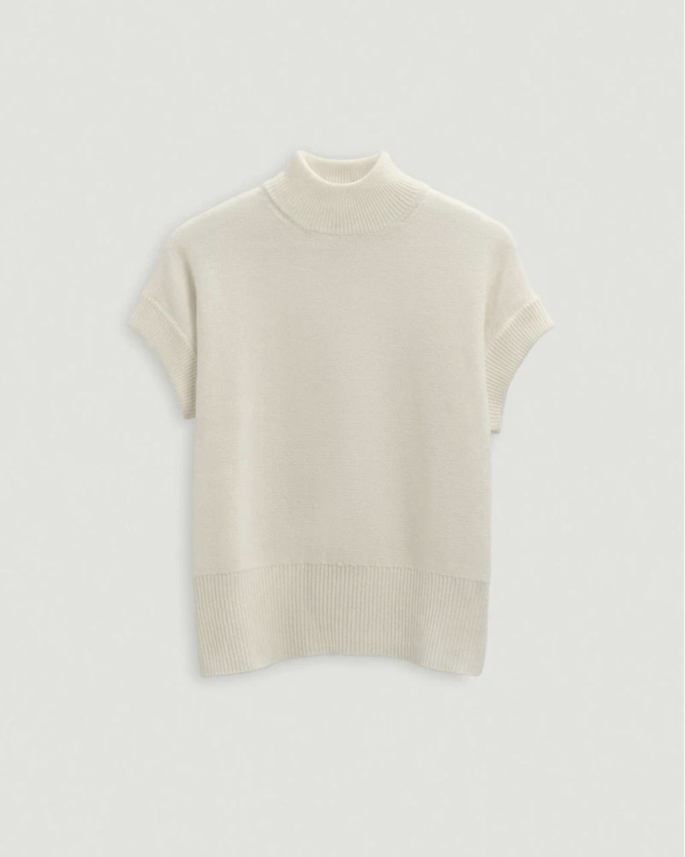 Beige turtleneck sweater on a light gray background.
