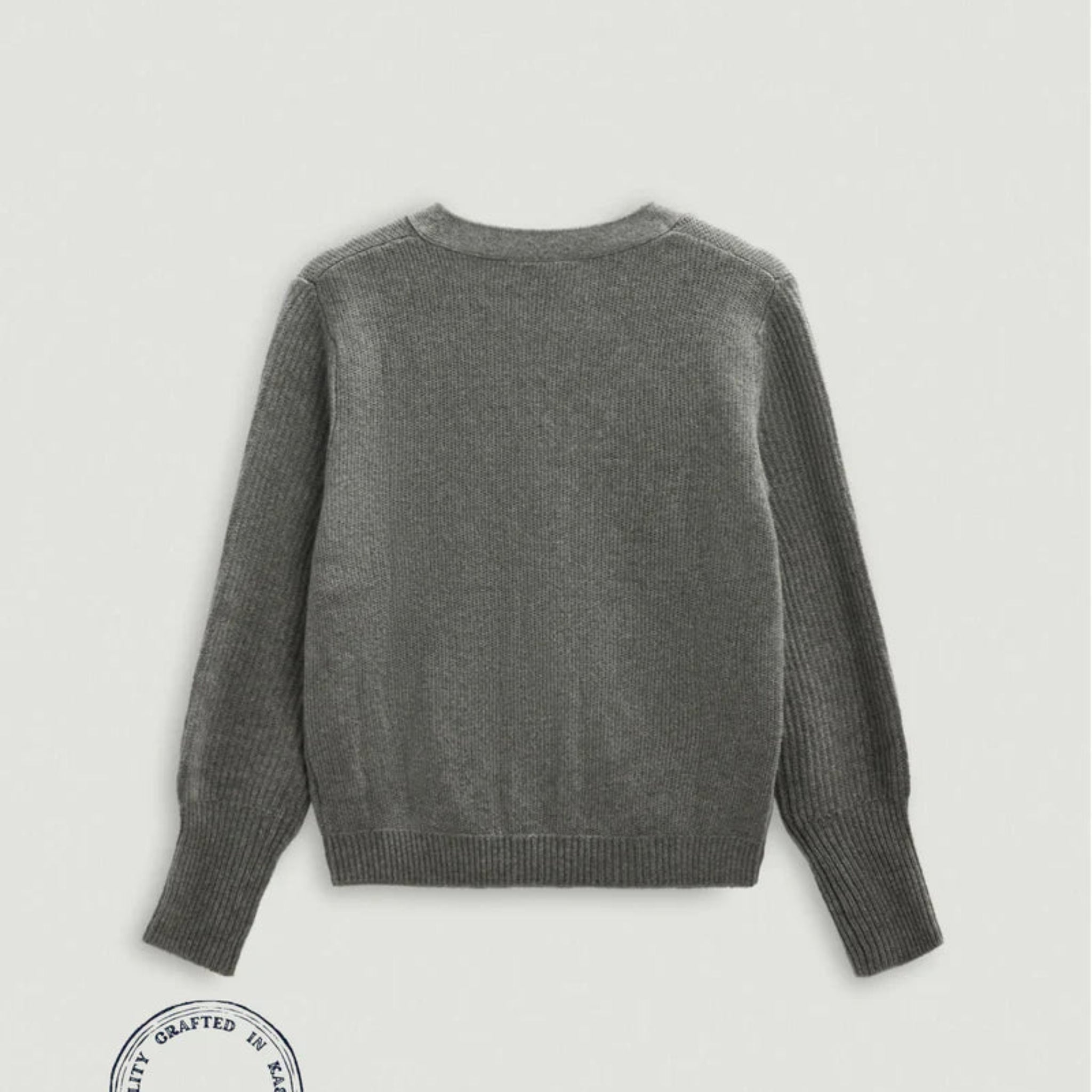 Gray sweater on a light gray background with a brand label at the bottom.