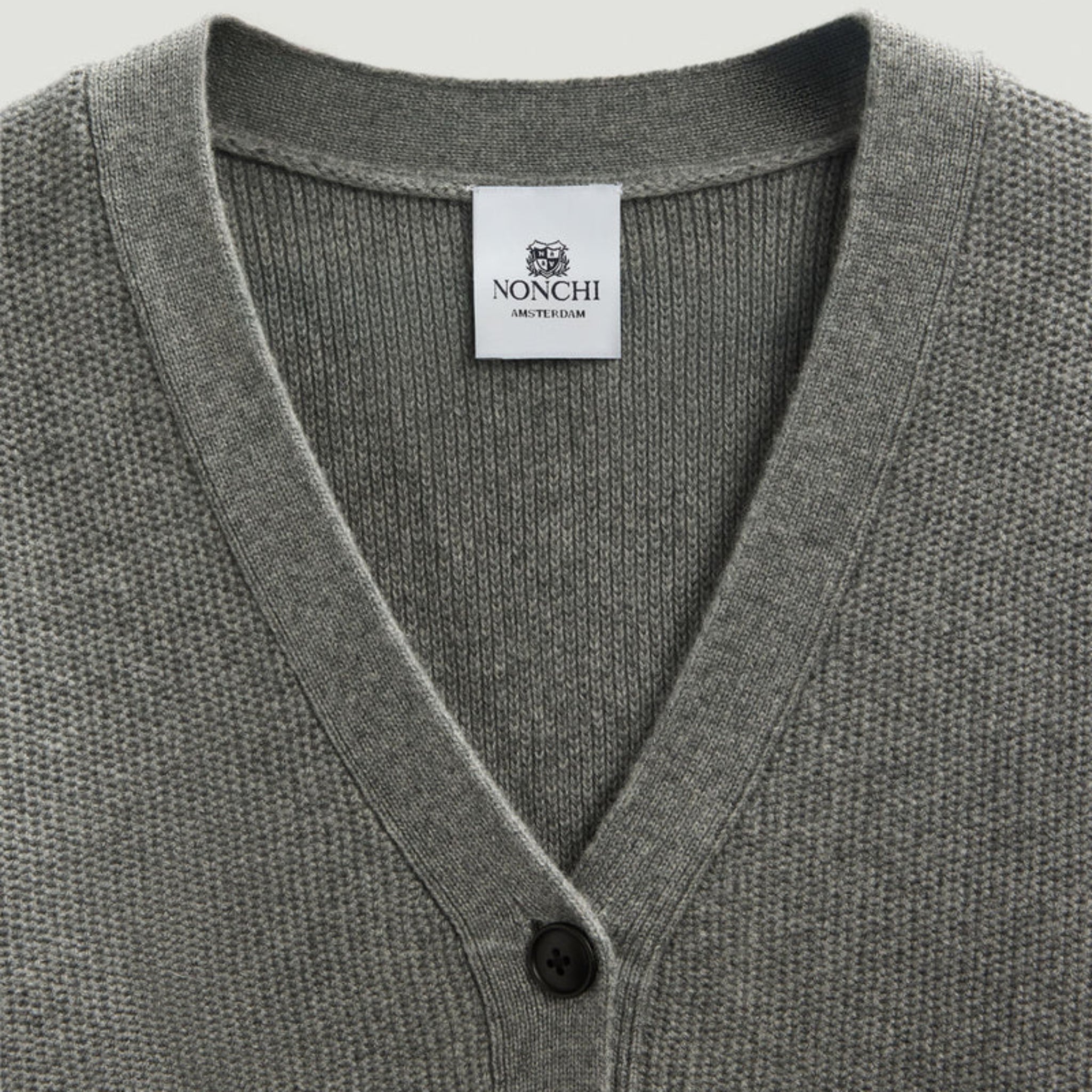 Gray cardigan with a visible Nonchi label on a light gray background