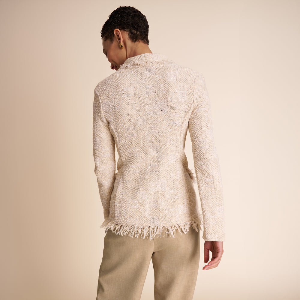 Person wearing a textured beige sweater with a plain background