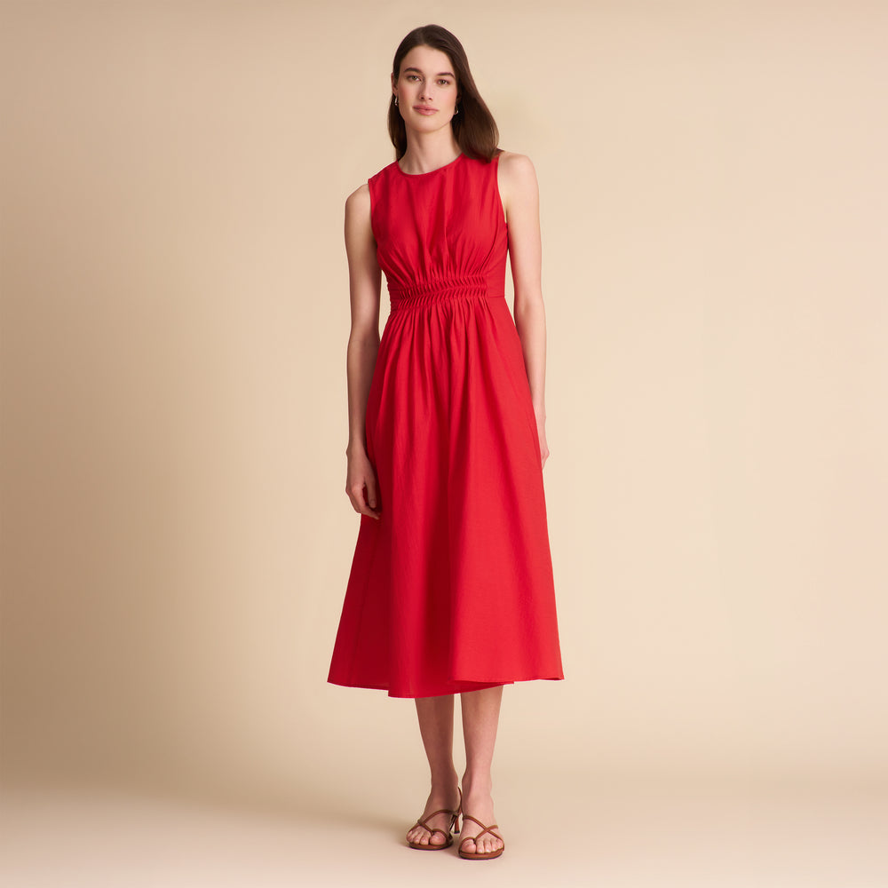Woman wearing a red dress against a beige background