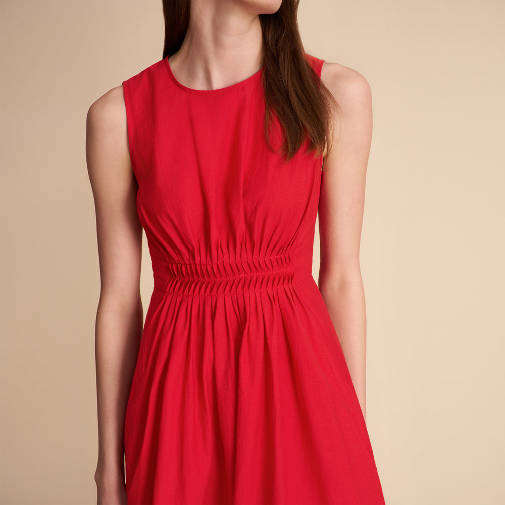 Woman wearing a red dress against a beige background