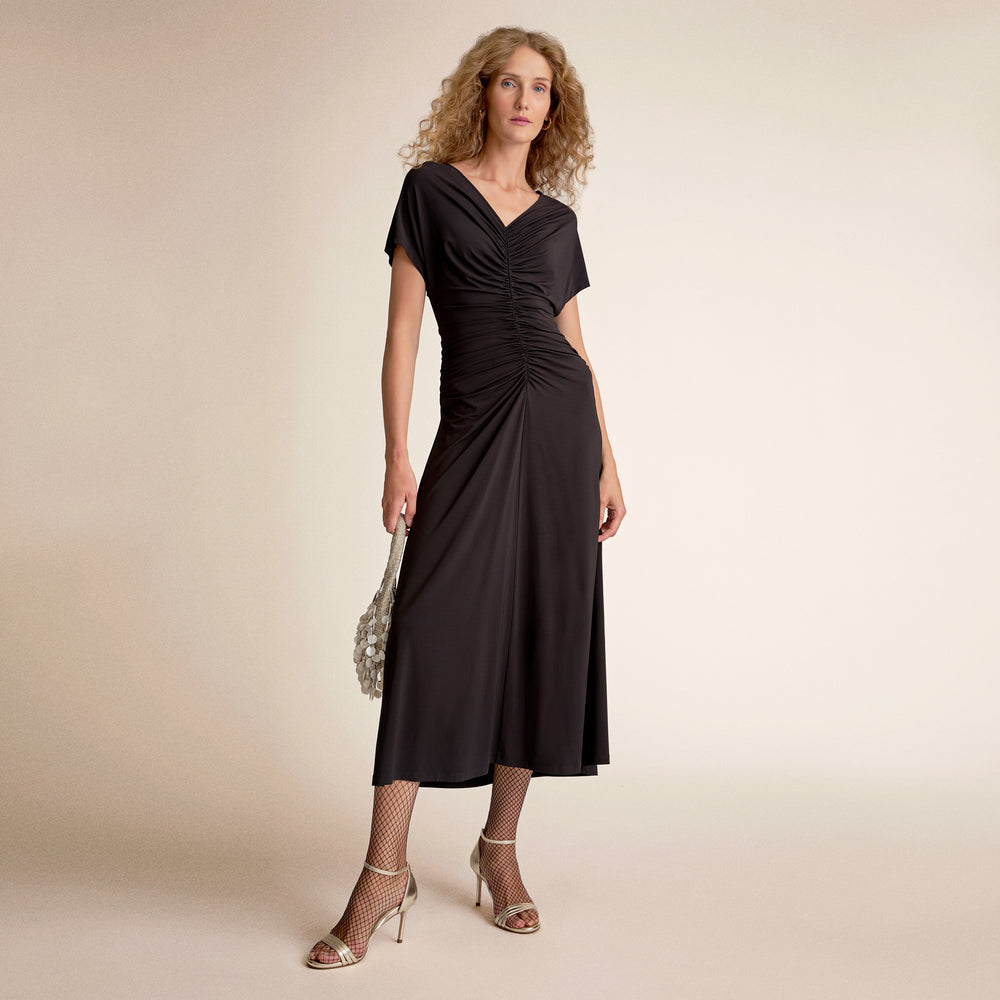 Woman wearing a black dress on a beige background